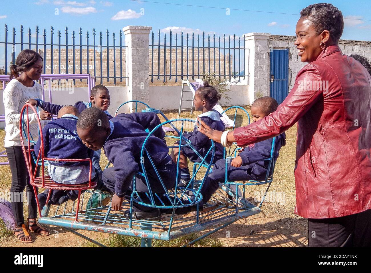 Mutelo Matokwani Right A Director At Proactive Ways Academy Plays With Children On The Swings During Break Time In Lusaka Zambia Stock Photo Alamy