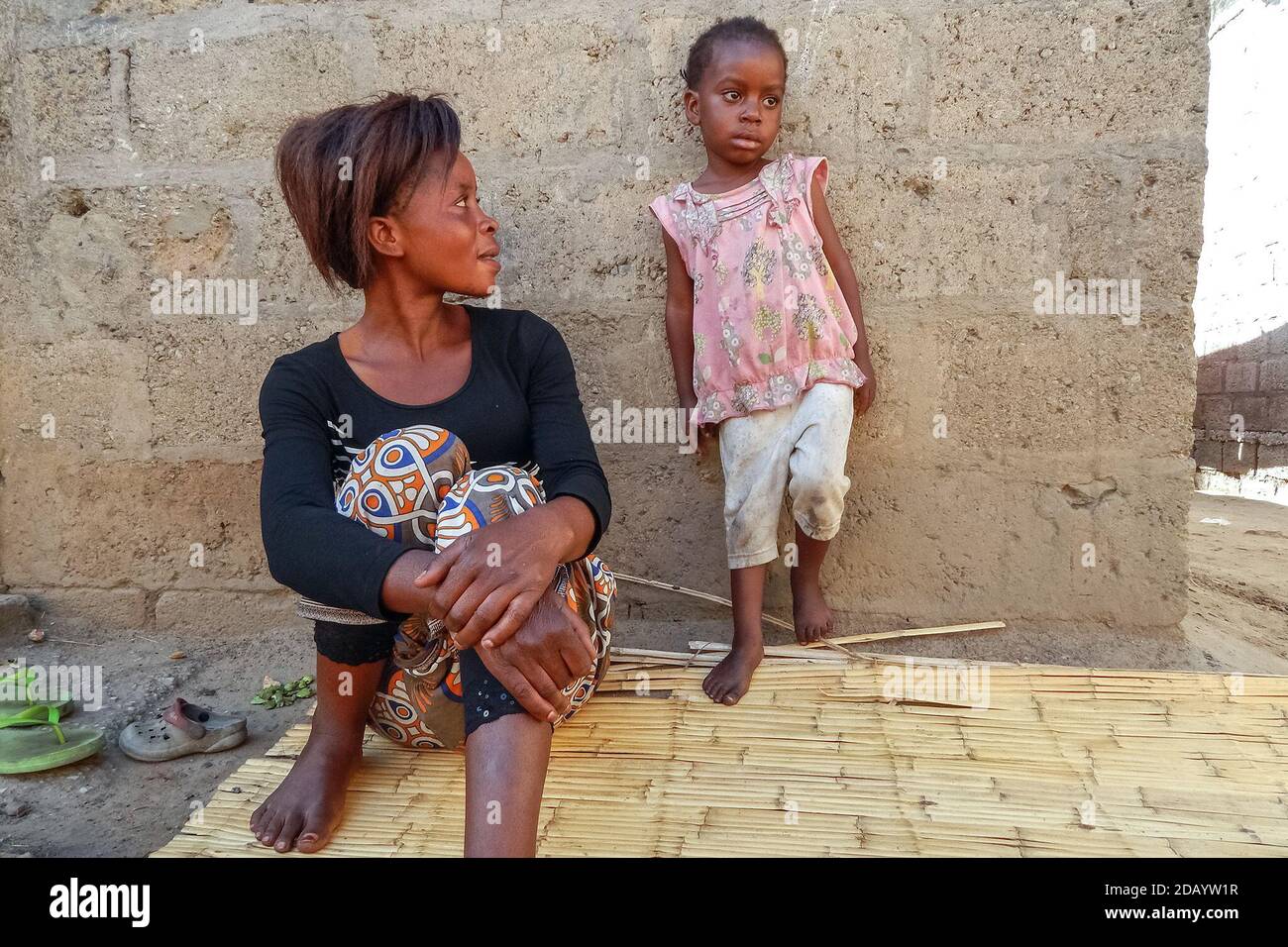 An HIV-positive woman, Alice Phiri, sits with her daughter outside of their home in Lusaka, Zambia. Stock Photo