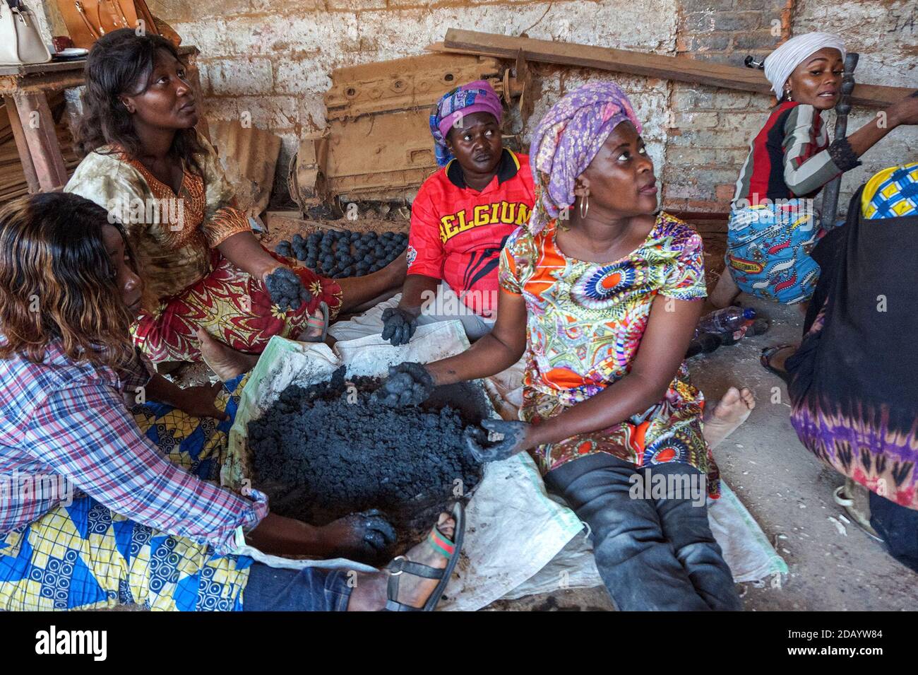 Women make clean-burning briquettes by hand to use in a fire or stove in Kisangani, Democratic Republic of Congo. Stock Photo