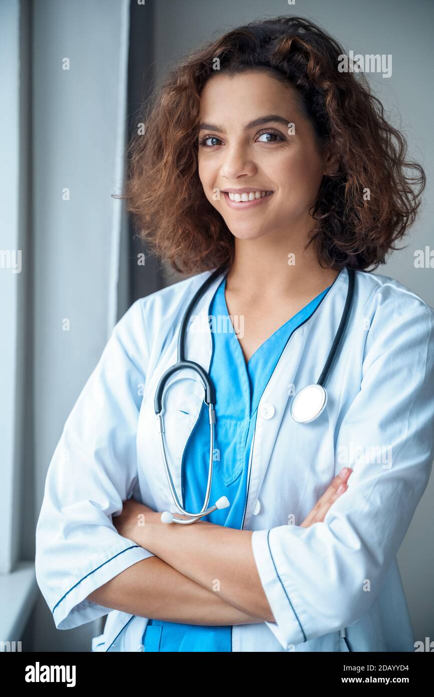 Vertical portrait of young female doctor wear smiling and looking at camera. Stock Photo