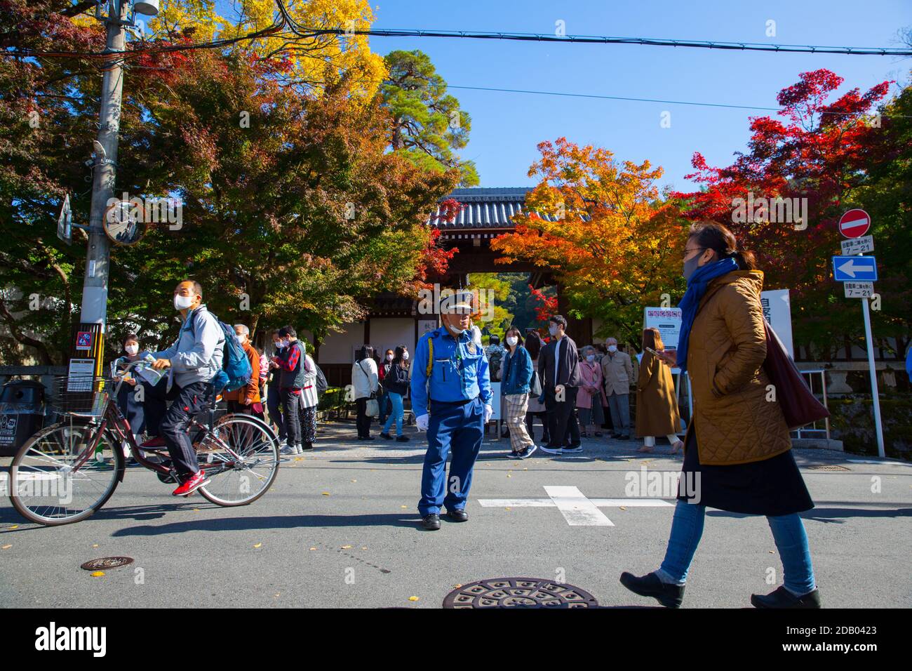 Kyoto, Japan. 14th Nov, 2020. Traffic guard stands in front of the main gate of Eikando Zenrin-Ji Temple in Kyoto during the Japanese autumn leaves season. Credit: SOPA Images Limited/Alamy Live News Stock Photo