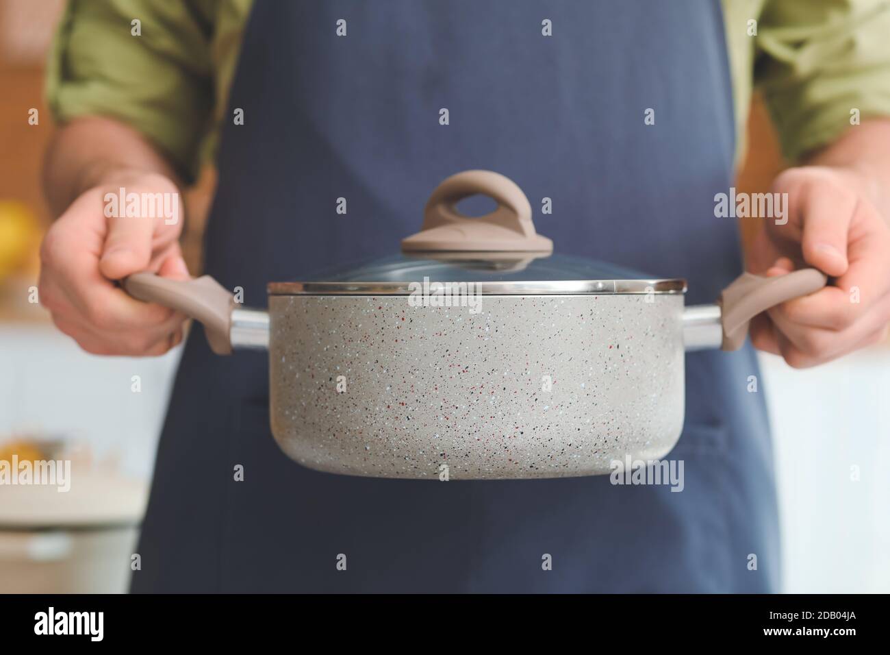 Man with cooking pot in kitchen, closeup Stock Photo - Alamy
