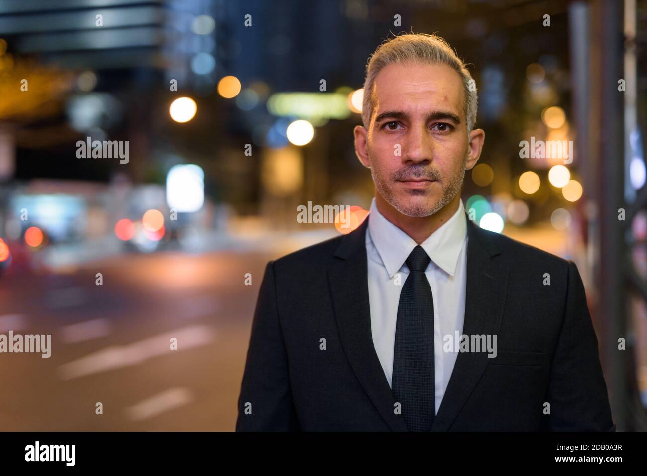 Portrait of handsome businessman wearing suit in city at night Stock ...