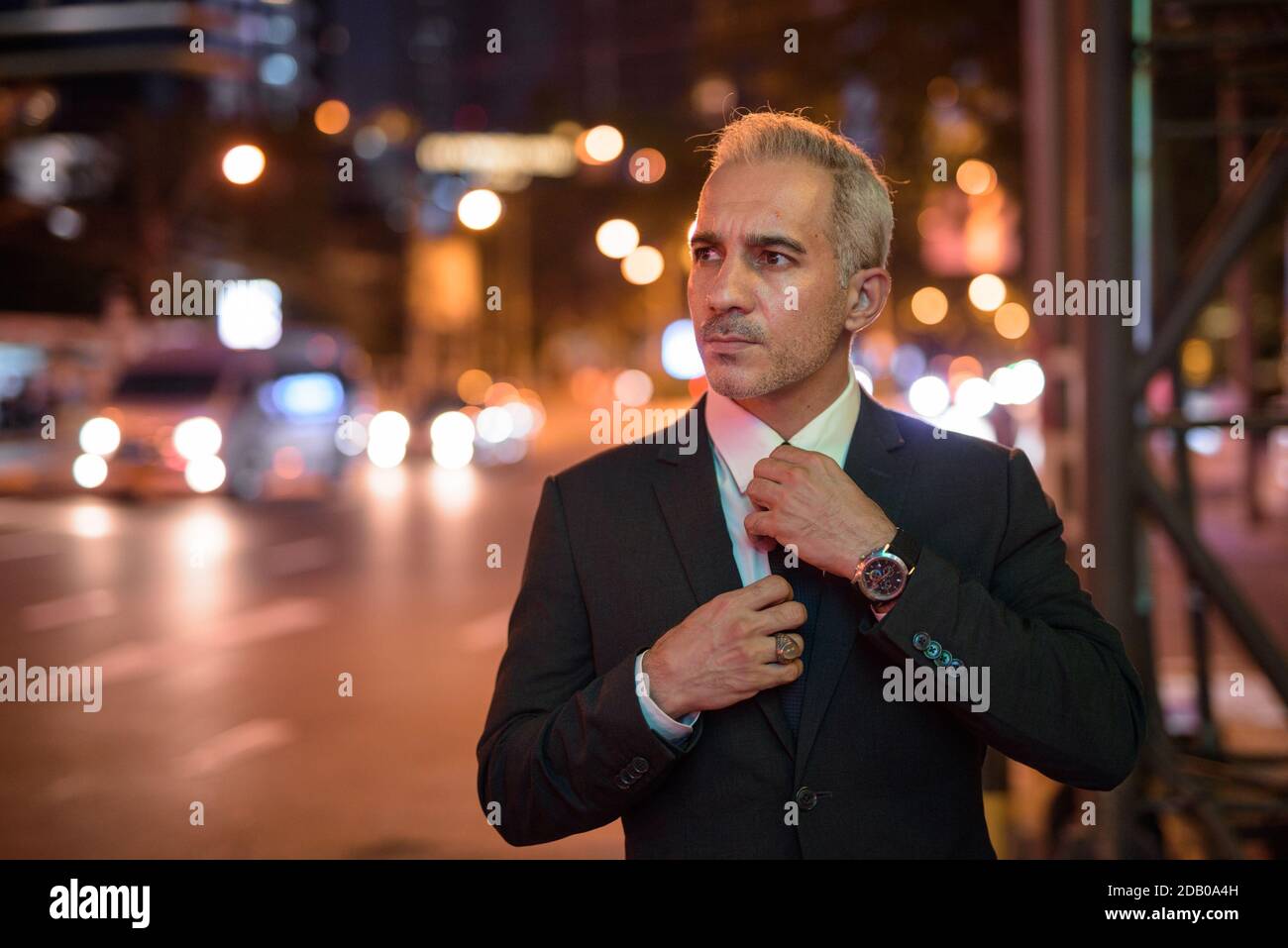 Portrait of handsome businessman wearing suit in city at night Stock ...