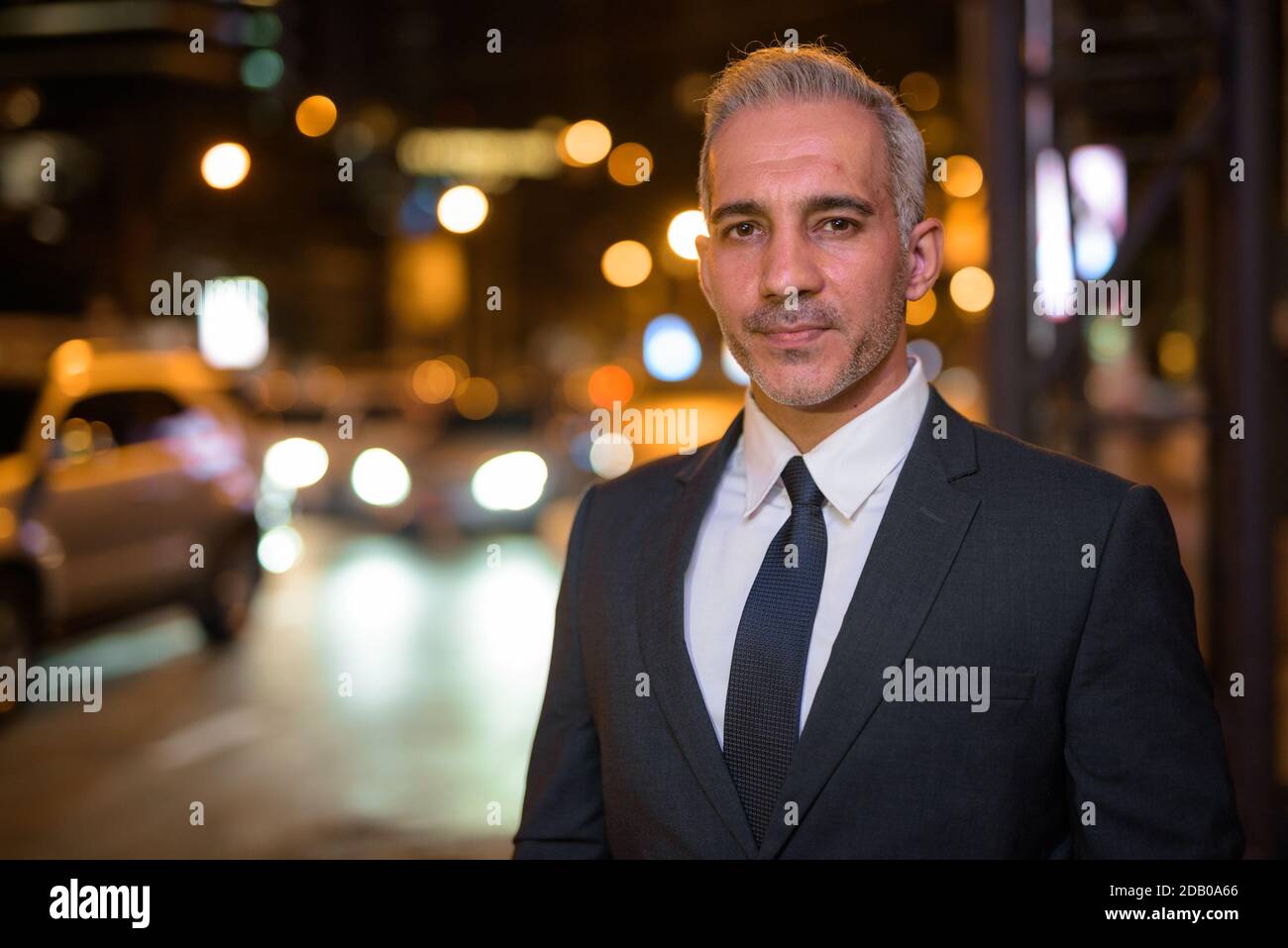 Portrait of handsome businessman wearing suit in city at night Stock ...