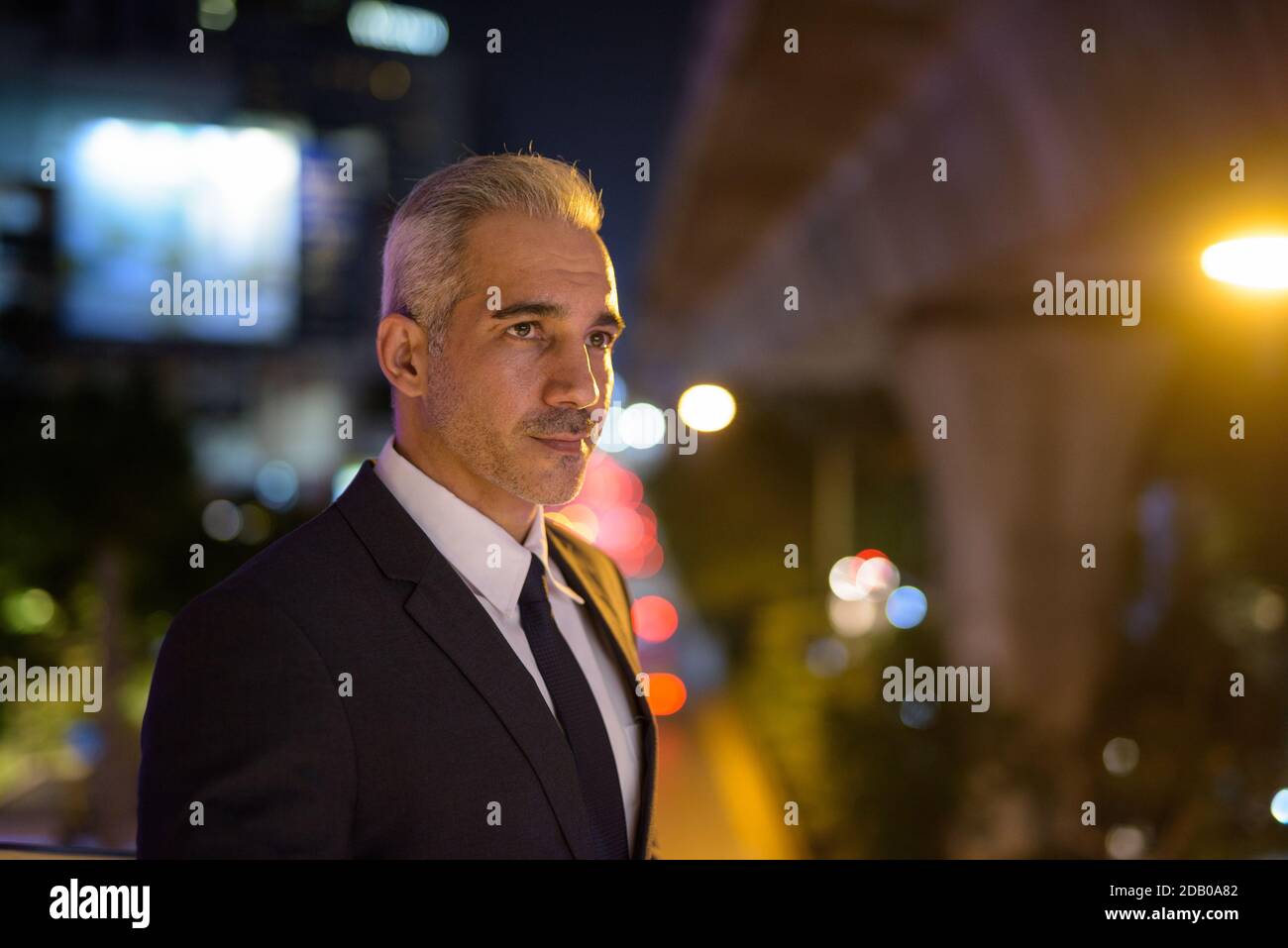 Portrait of handsome businessman wearing suit in city at night Stock ...