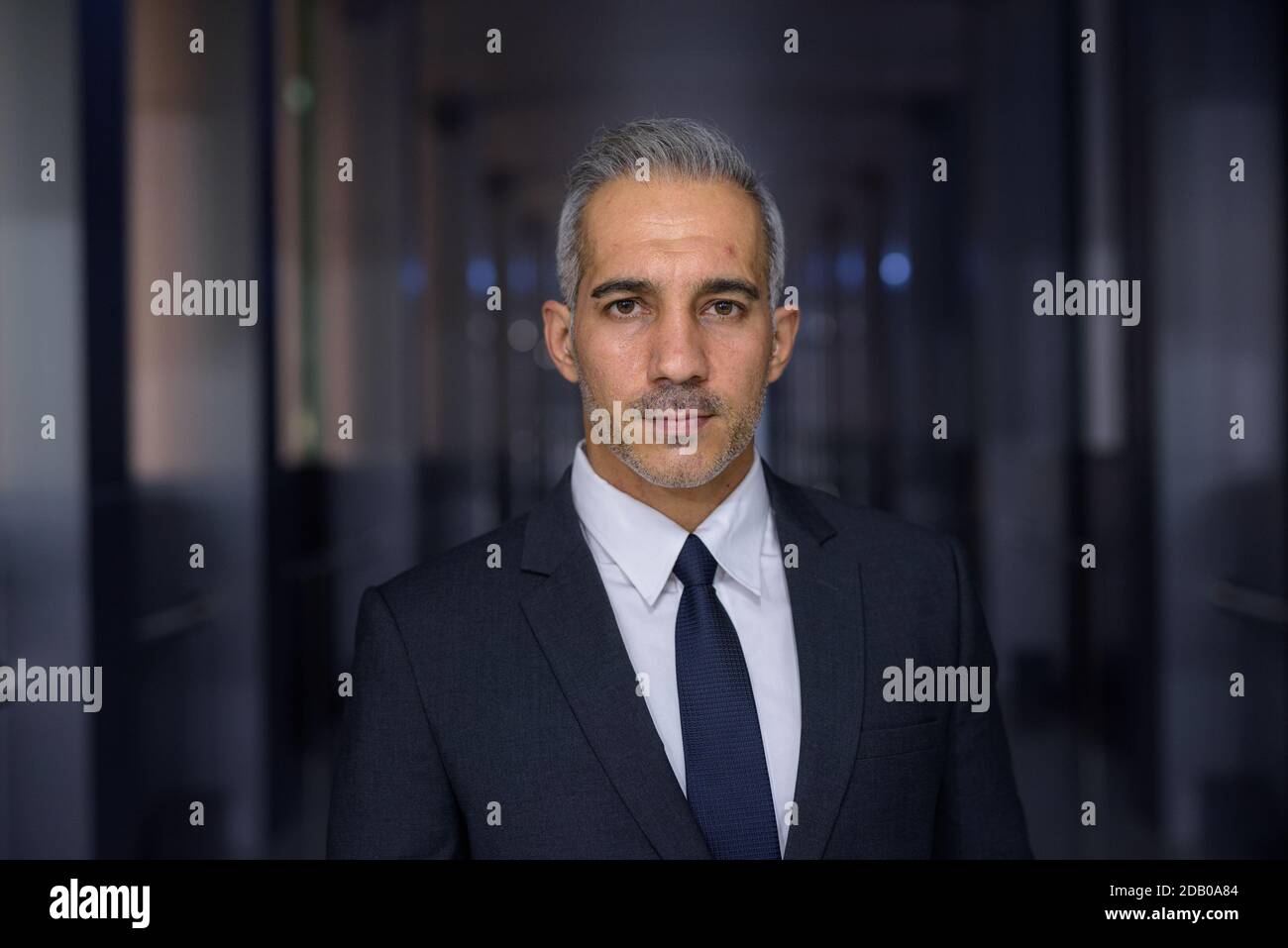 Portrait of handsome businessman wearing suit and looking at camera ...