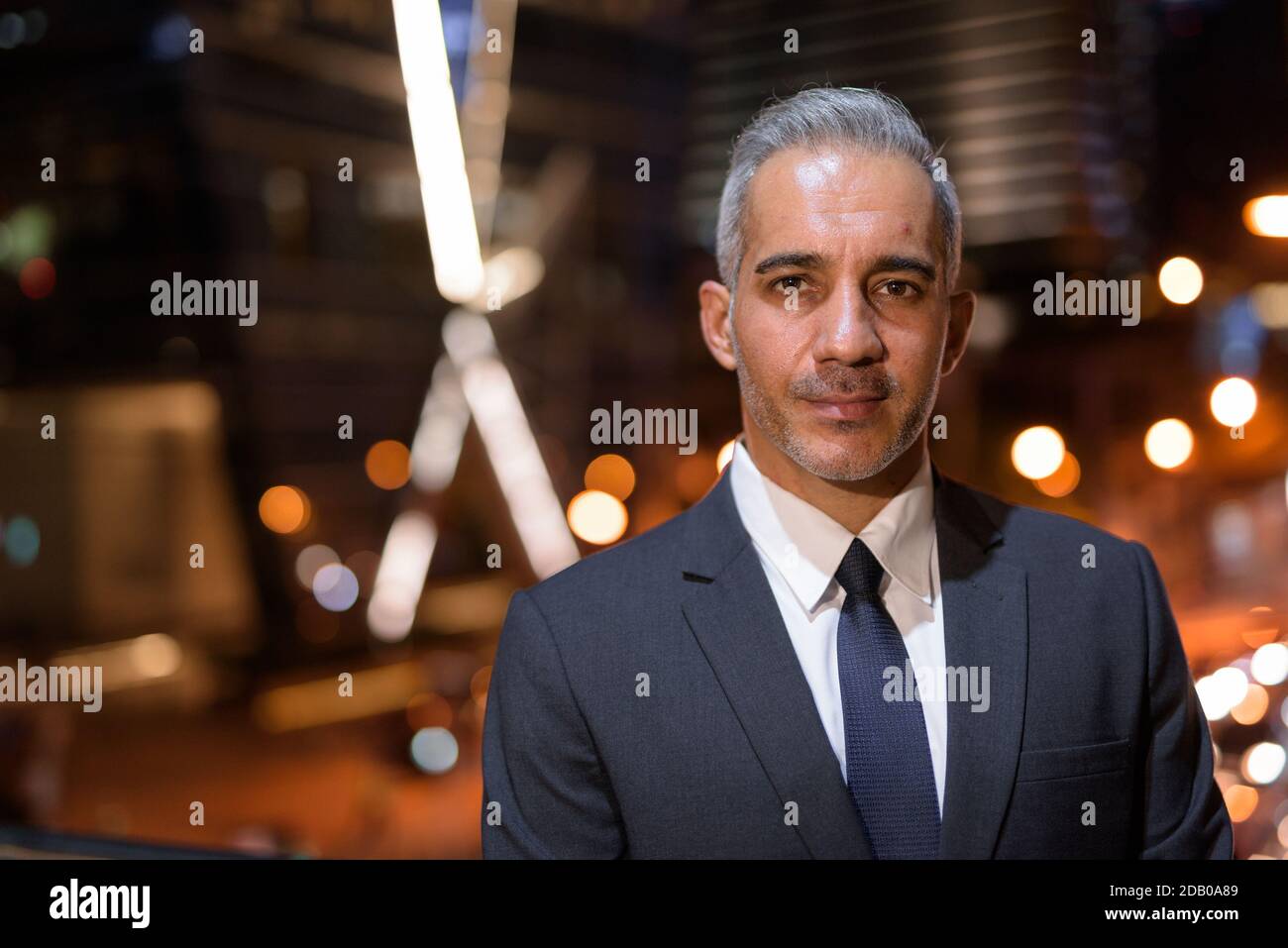 Portrait of handsome businessman wearing suit in city at night Stock ...