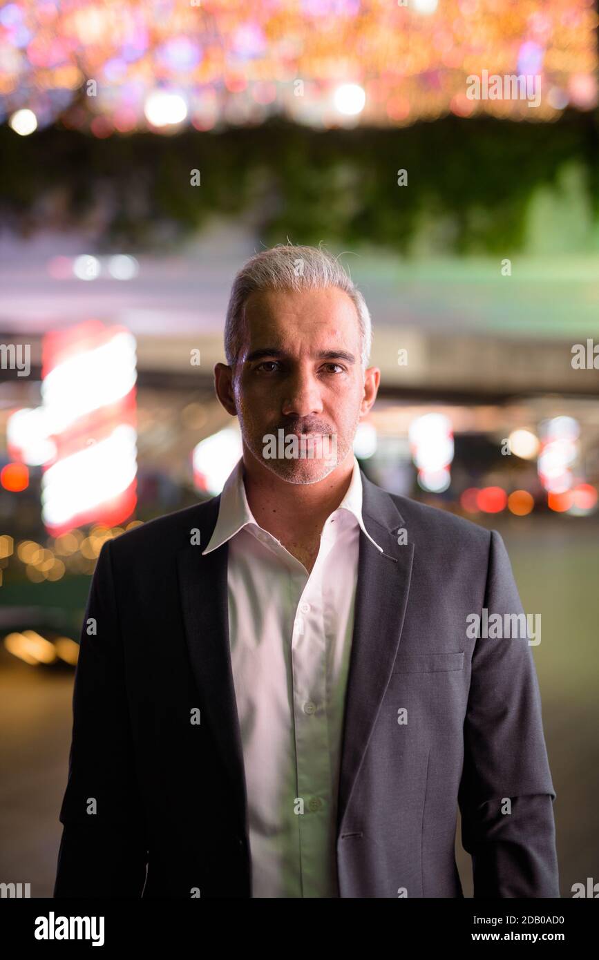 Portrait of handsome businessman wearing suit in city at night Stock ...