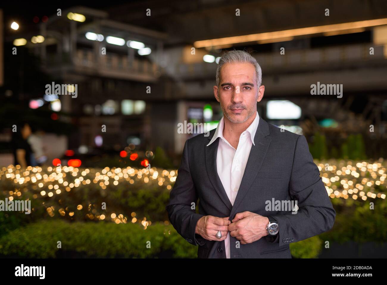 Portrait of handsome businessman wearing suit in city at night Stock ...