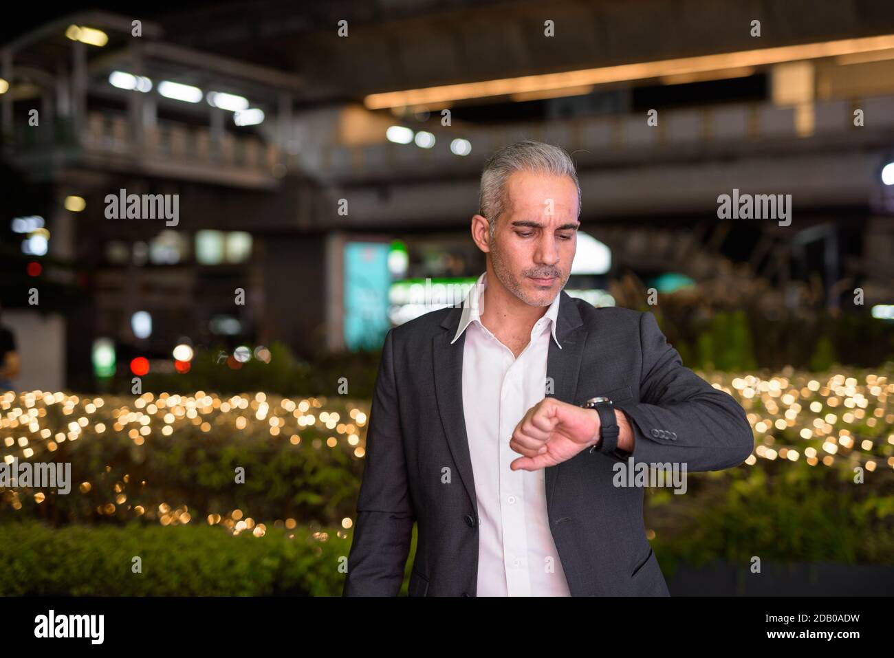 Portrait of handsome businessman wearing suit in city at night Stock ...