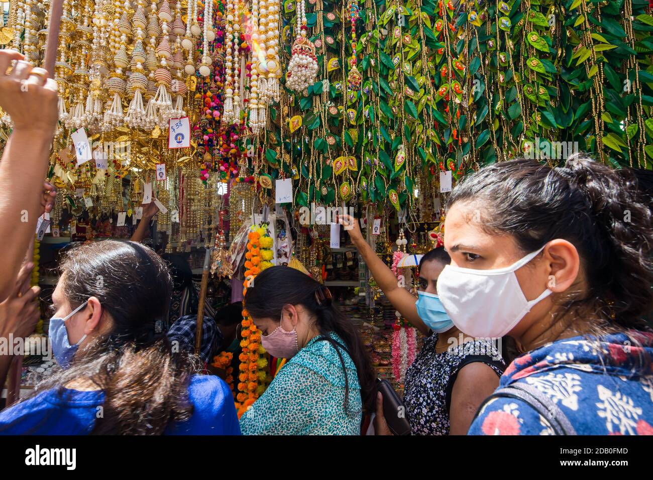 Street scene of Indian women choosing decorative items hanging on top. Singapore. 2020 Stock Photo
