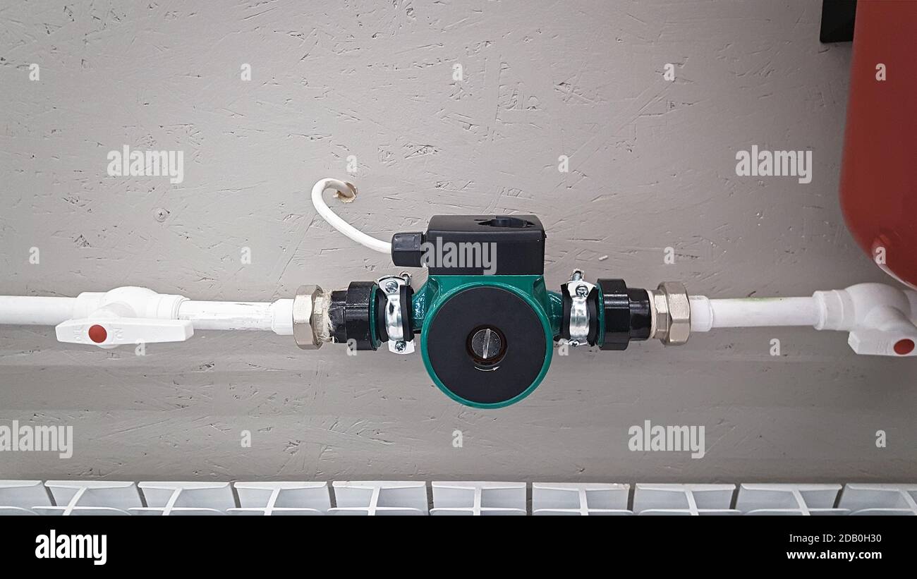 Green heating circulation pump mounted on a pipe. Independent heating