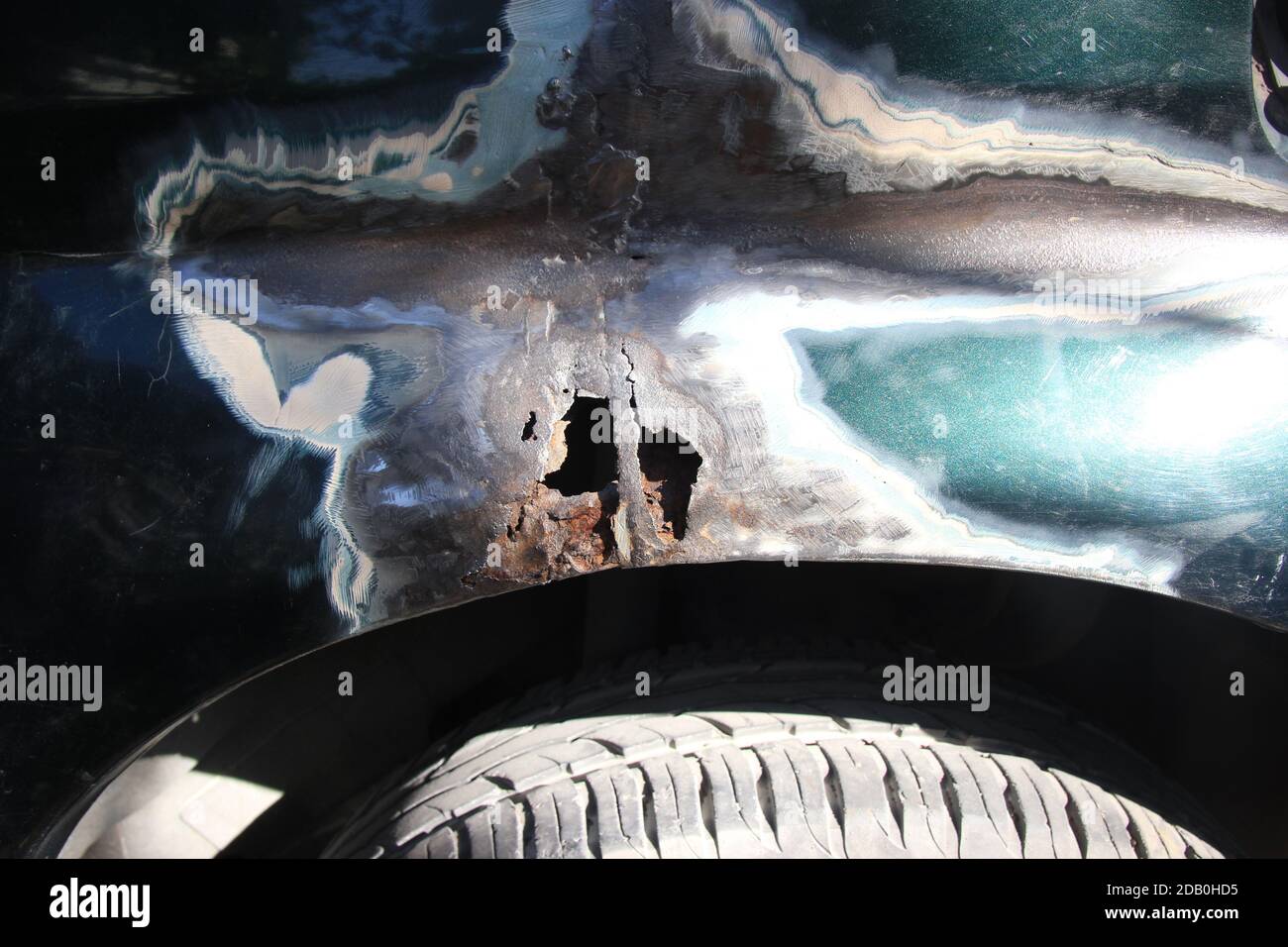 Metal corrosion on a car fender, rust hole. car body repair. Front view