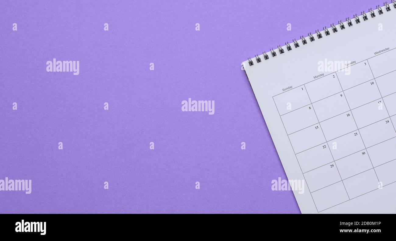 Calendar on purple background. Top view. Copy space. Stock Photo