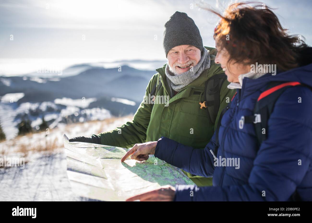 Senior couple hikers using map in snow-covered winter nature Stock ...