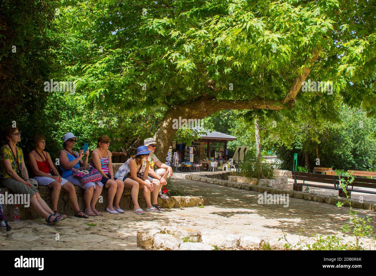 4 May 2018 A small group of tourists sit in the shade during a visit to the ancient Banias Water Gardens and pathways at the bottom of Mount Hermon Stock Photo