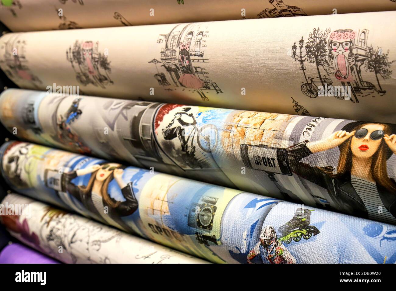 Rolled up rolls of vinyl wallpaper in a building supermarket, shop. Colorful wallpaper for the wall, decorative materials for the renovation of a room Stock Photo