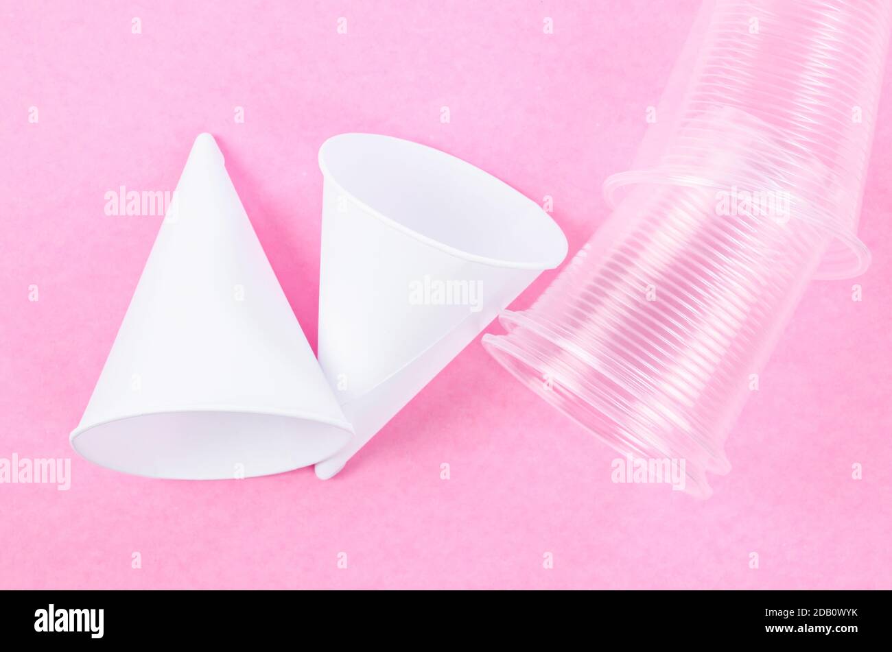 Disposable paper cone water cups and plastic water cups on pink