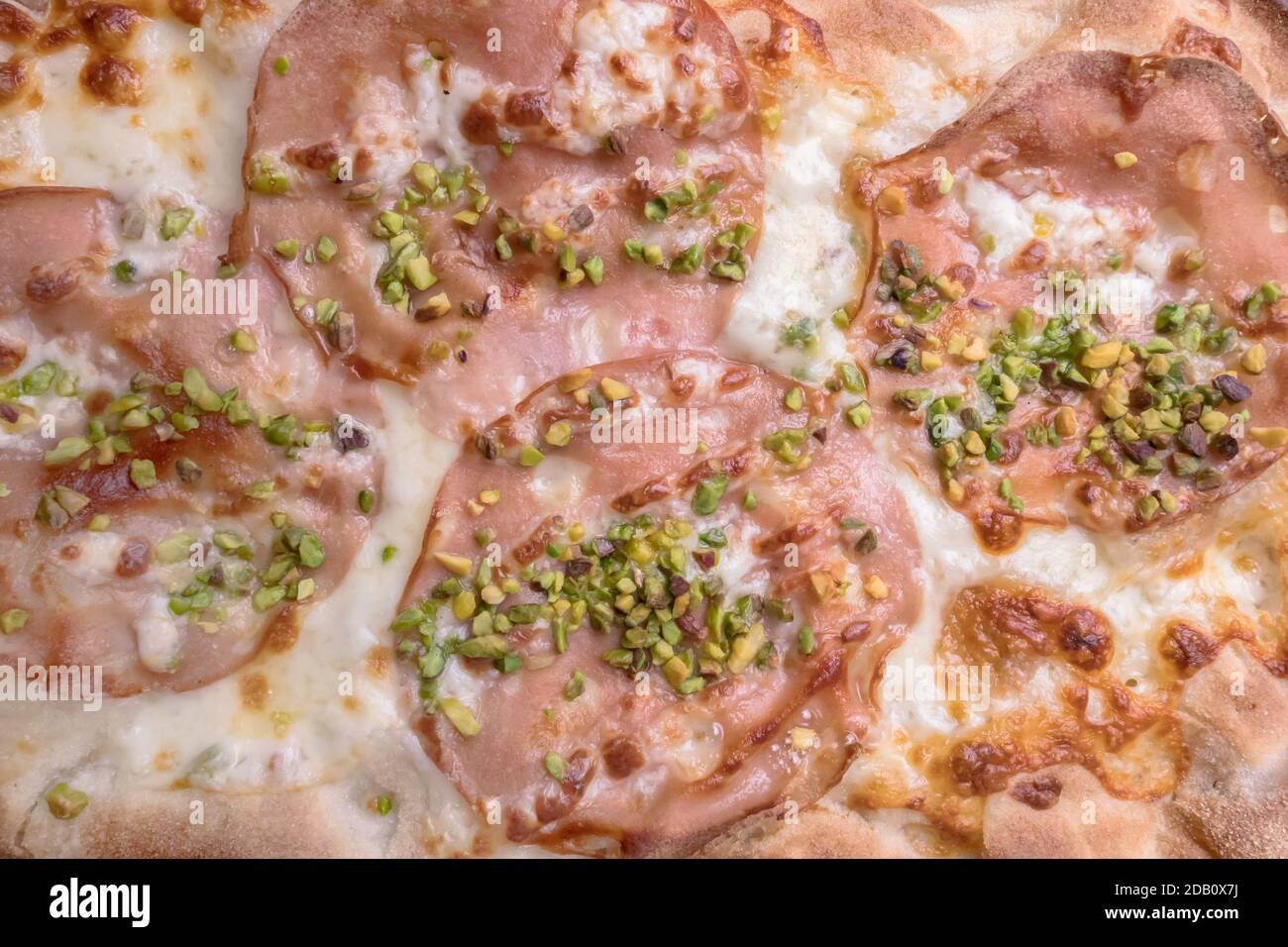 Gourmet pizza with mortadella, pistachio grains and mozzarella Stock