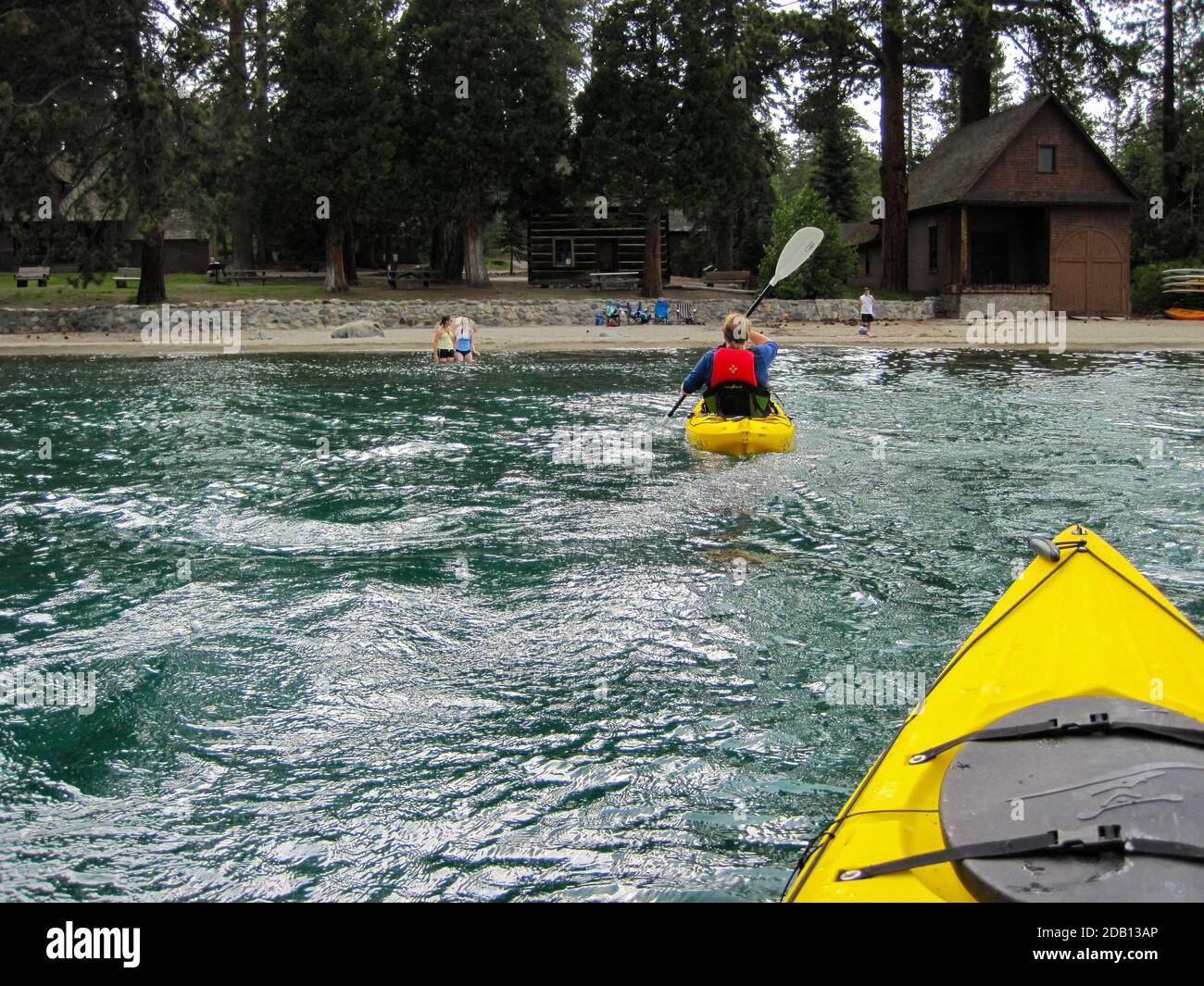 Kayakers returning to beach at Sugarpine State Park, from the perspective of rear kayak, choppy