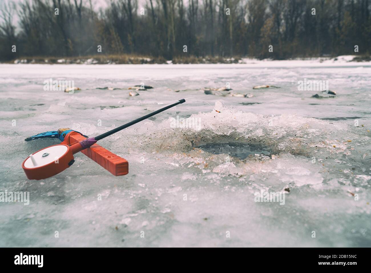 Fishing rod for winter fishing, scoop, and hole in the ice Stock Photo