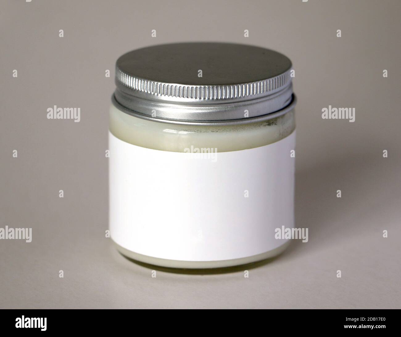 Glass jar with blank white label containing candle or creme Stock Photo