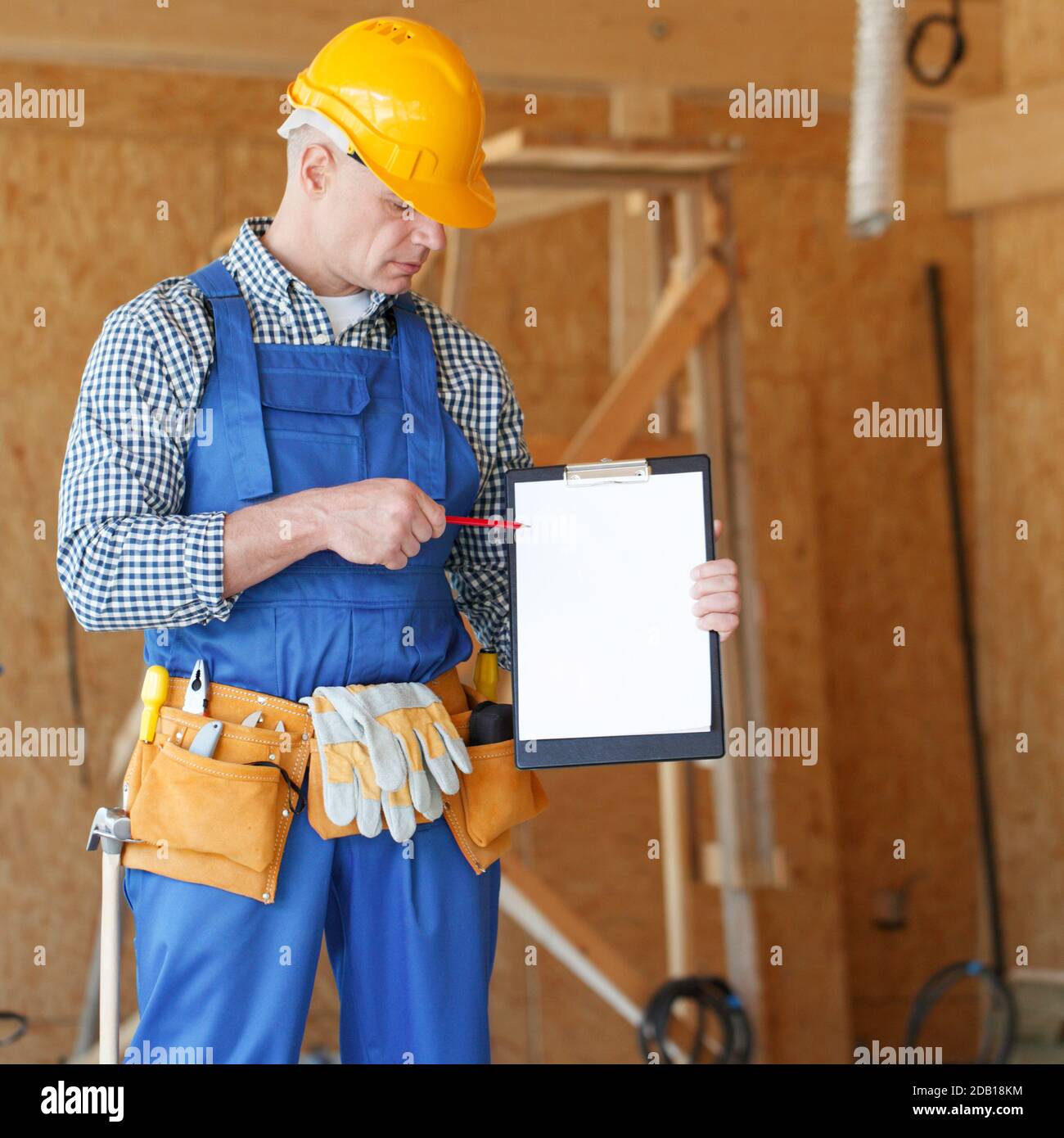 Worker showing document at construction site area, blank copy space for text Stock Photo