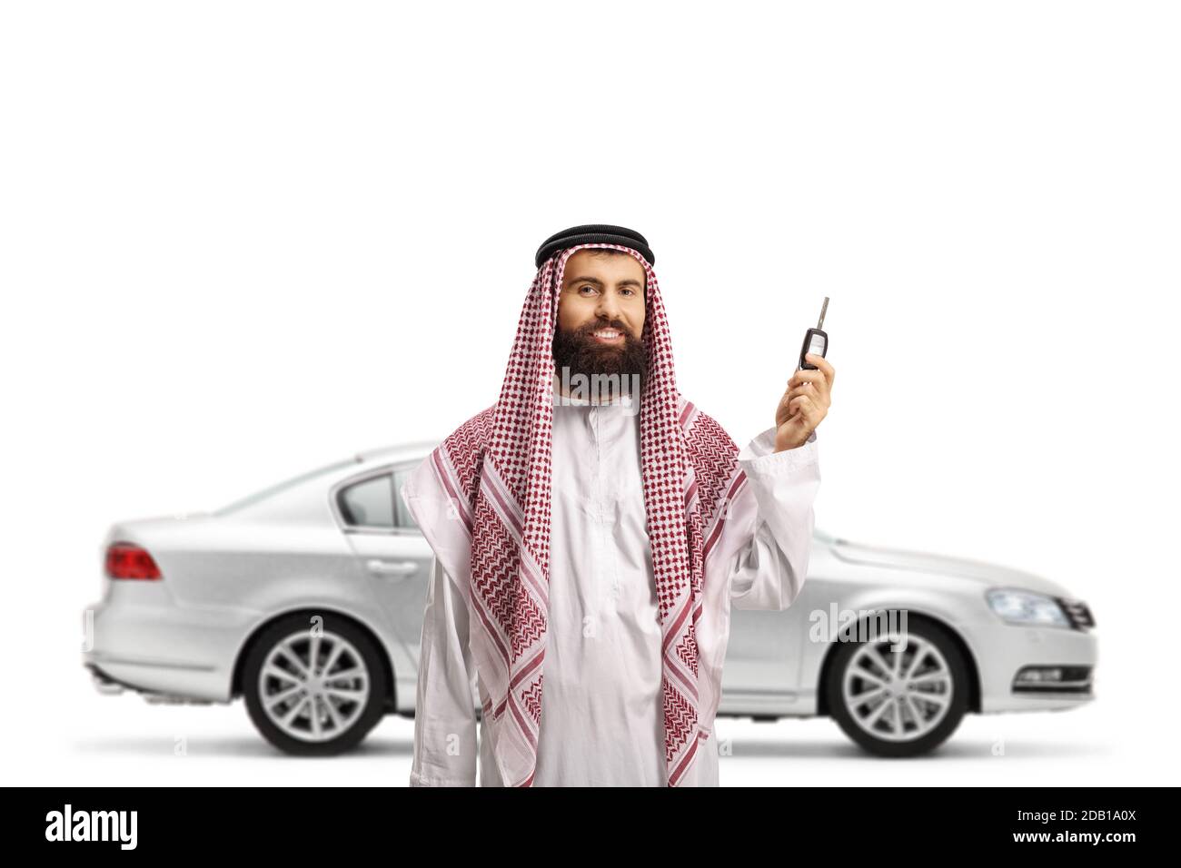 Saudi arab man holding car keys from a new silver car isolated on white background Stock Photo