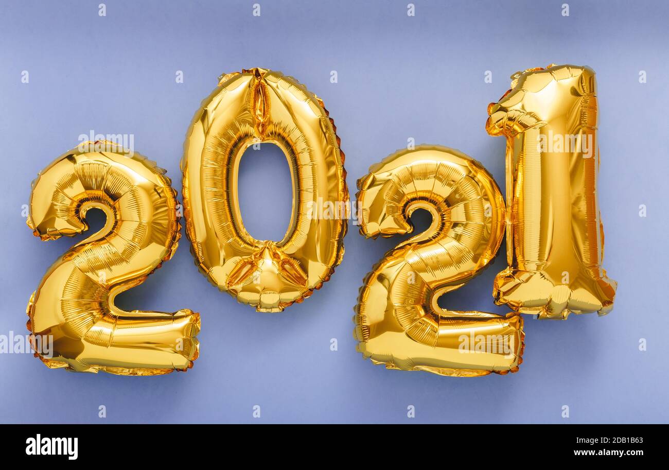 2021 air balloon gold text on violet background. Happy New year eve invitation with Christmas gold foil balloons 2021. Stock Photo