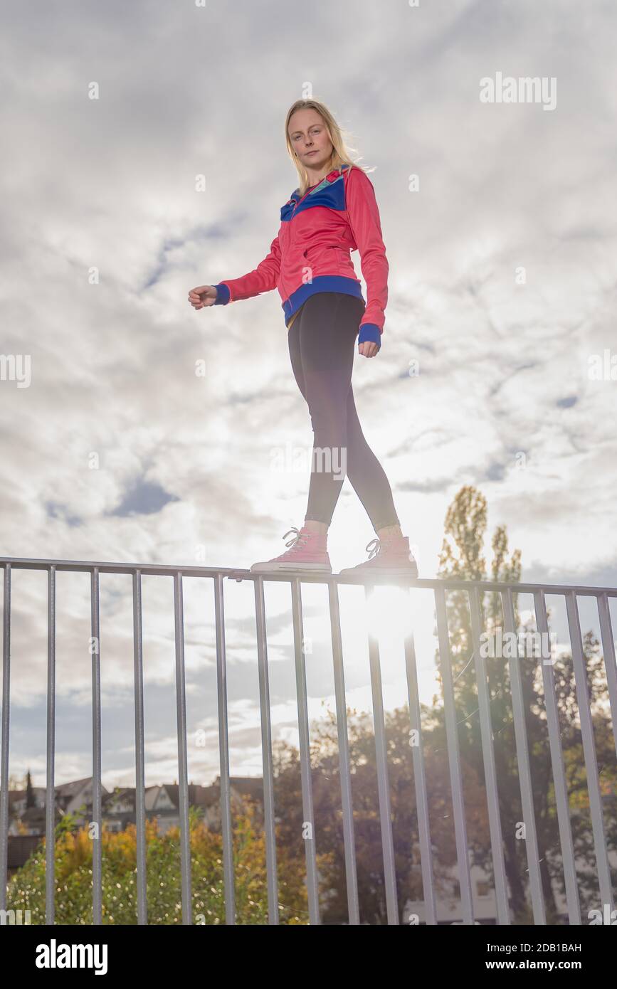 Balancing On Railing young woman balancing on a handrail, urban scenery in autumn Stock ...