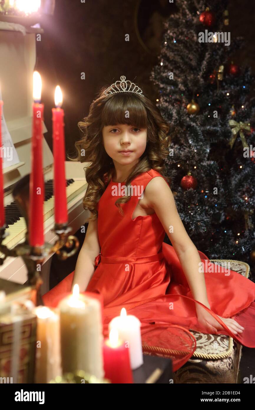 Beautiful girl in a red dress plays the piano Stock Photo - Alamy