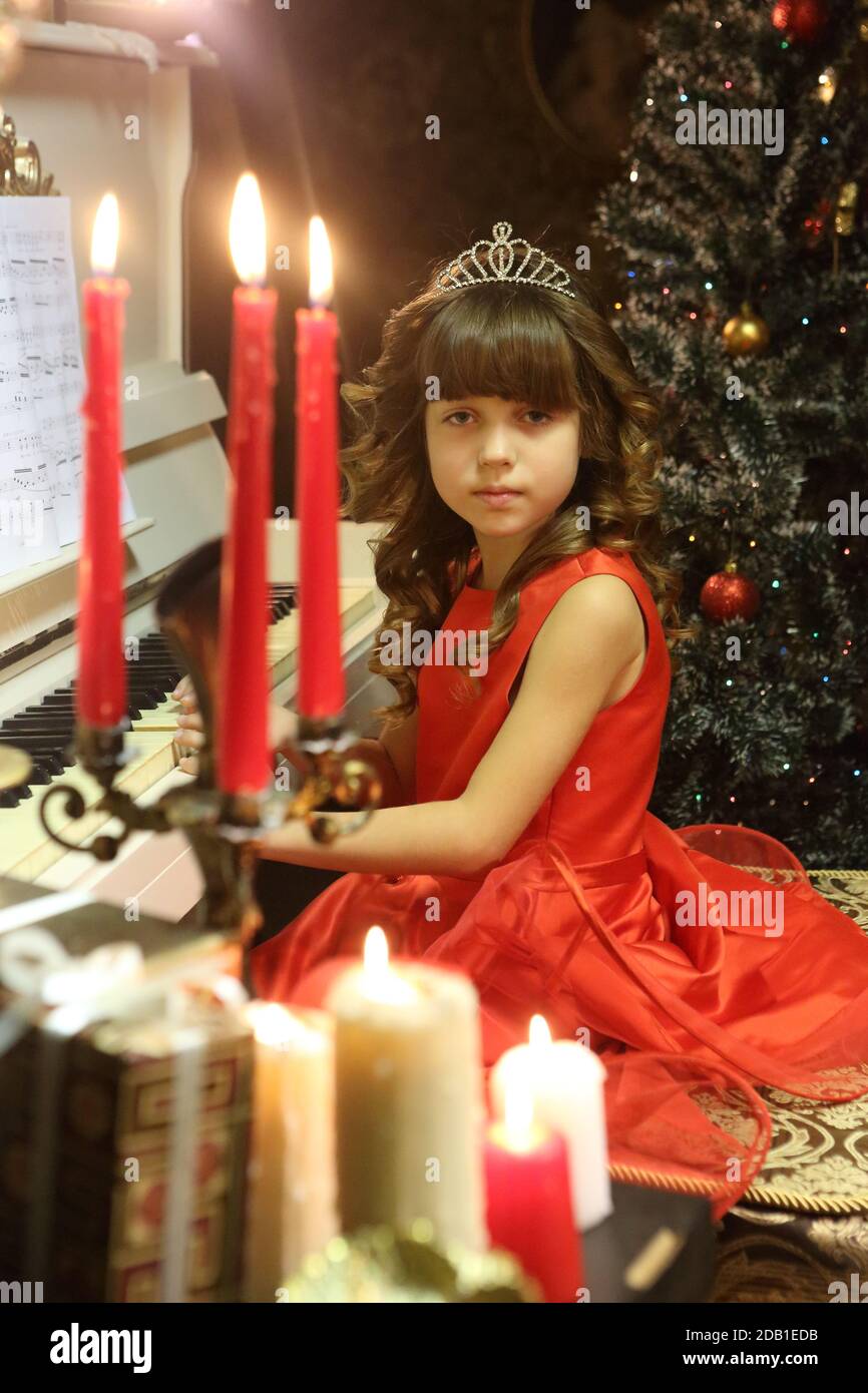 Beautiful girl in a red dress plays the piano Stock Photo - Alamy