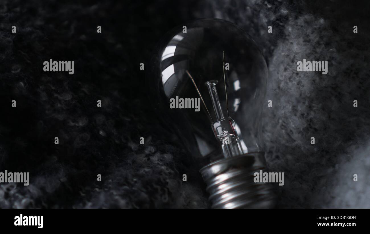 Light Bulb On a dark gray knitted background Stock Photo