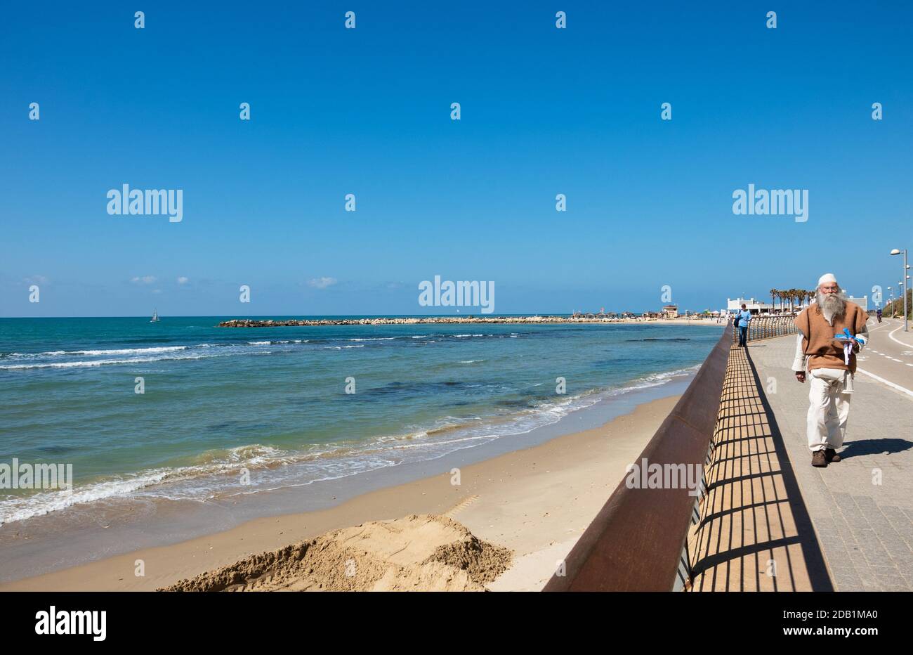 TEL AVIV, ISRAEL - MARCH 6, 2019: Senior man walking along beach promenade at Tel-Aviv in sunny day. For aged persons, walking offers numerous heart h Stock Photo