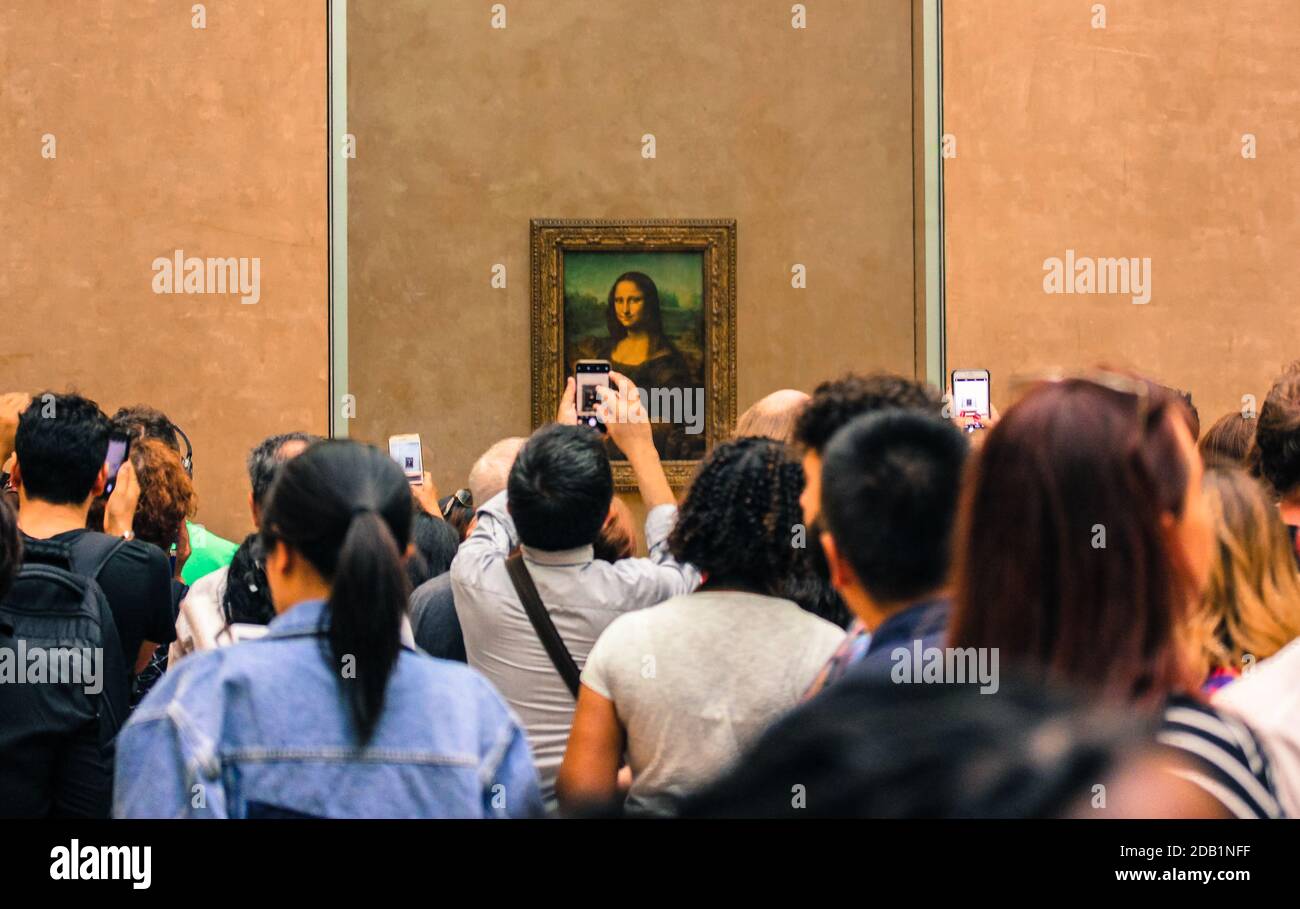 Tourists photograph a work of art in the Louvre Museum, Paris. Painting Leonard da Vinci Mona Lisa. World Heritage Stock Photo