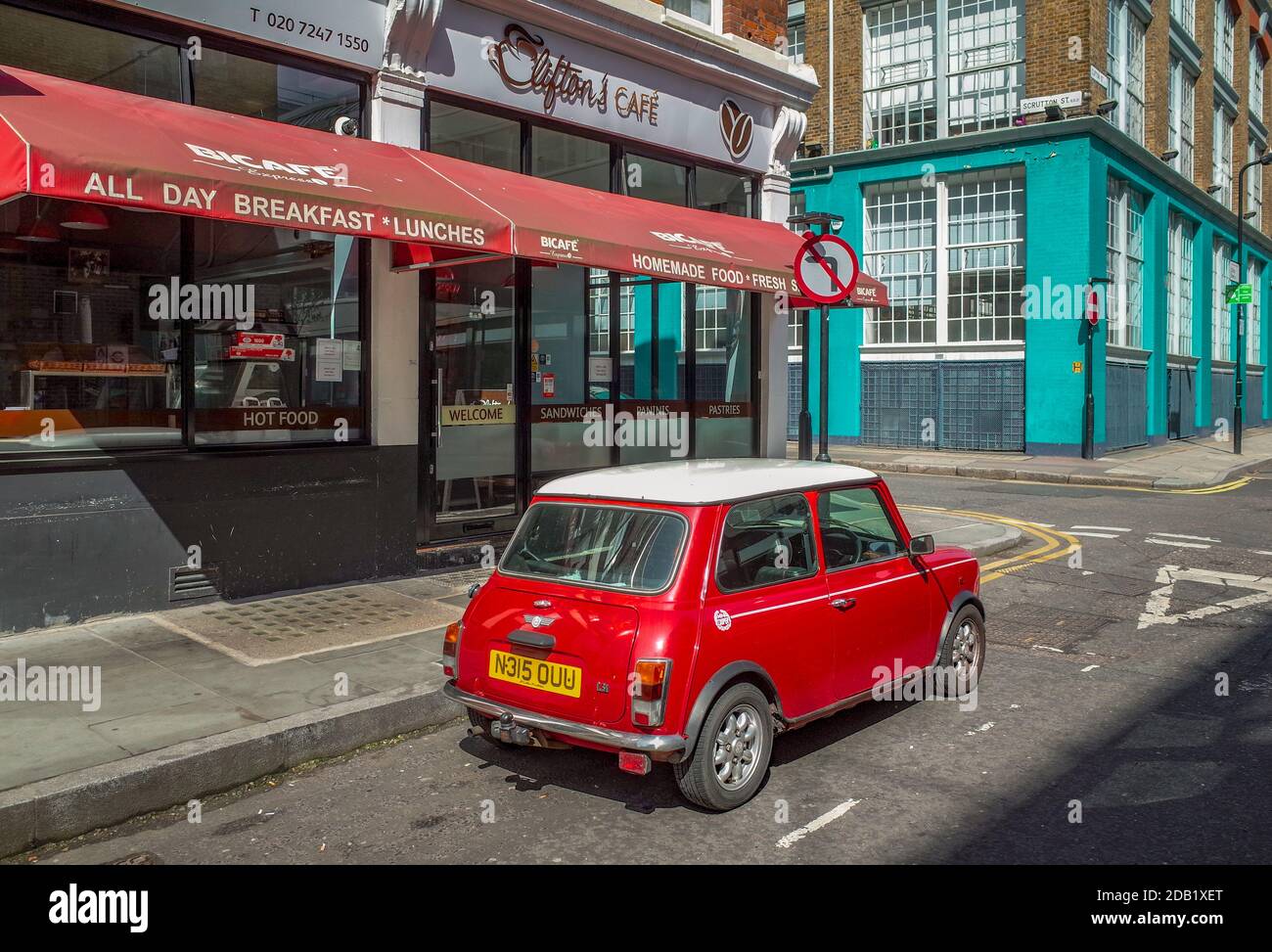 Vintage Mini parked outside a Clifton's Cafe in London's Shoreditch district. Red and White Classic Mini Cooper 1.3i London. Stock Photo