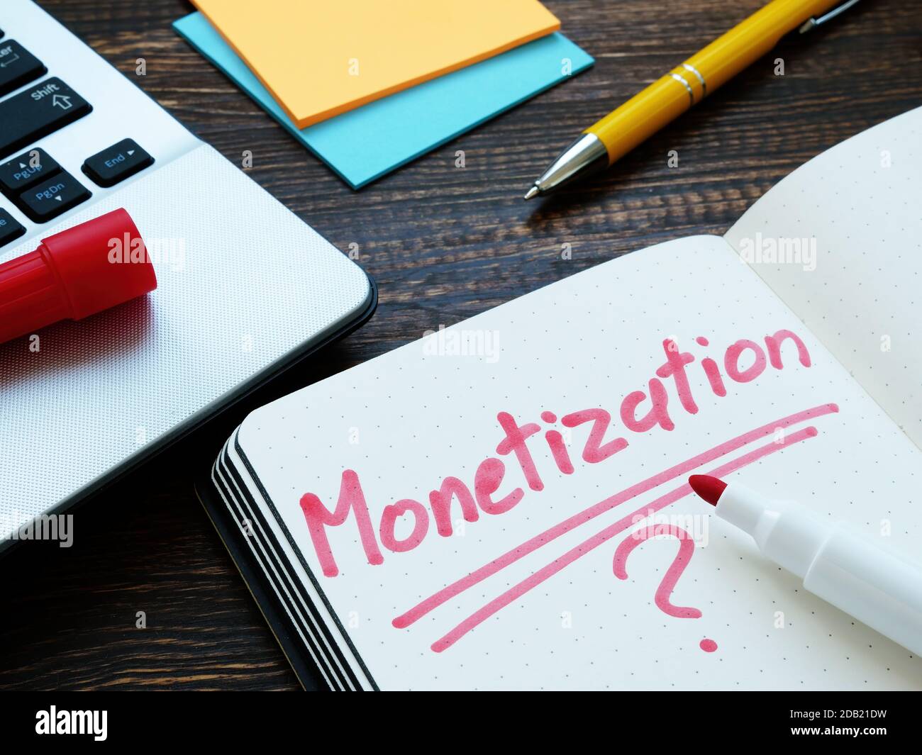 Monetization and question mark on notepad page and notebook Stock Photo ...
