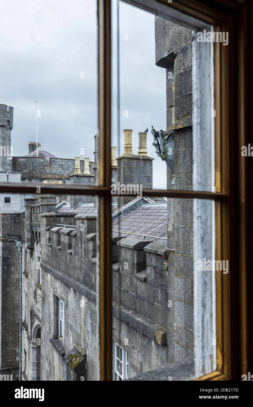 Looking out to the chimney pots and castellated stone on the roof of Kilkenny castle, County Kilkenny, Ireland Stock Photo