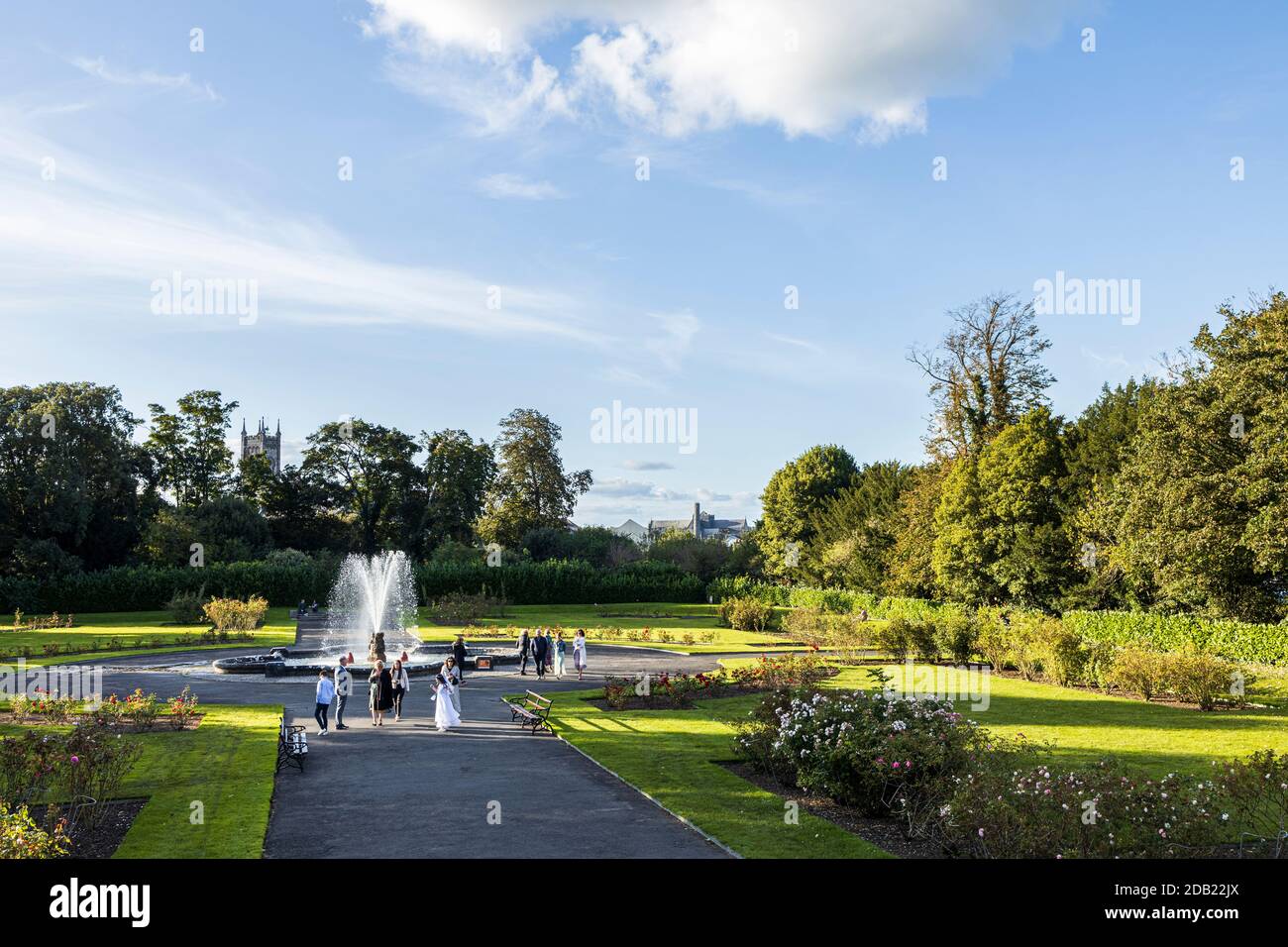 Girl in communion dress and family by the fountain and gardens in the grounds of Kilkenny Castle, County Kilkenny, Ireland Stock Photo