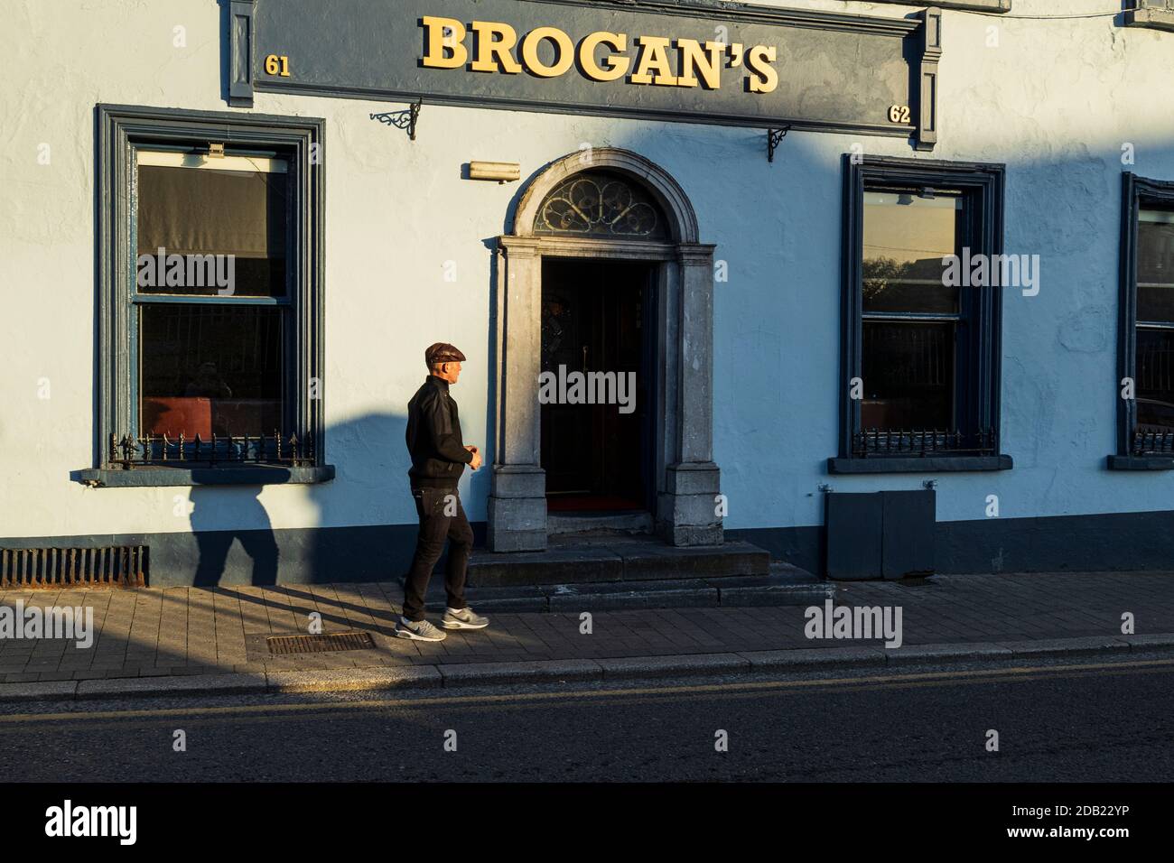 Man in flat cap, on John street outside Brogans public house in Kilkenny, County Kilkenny, Ireland Stock Photo