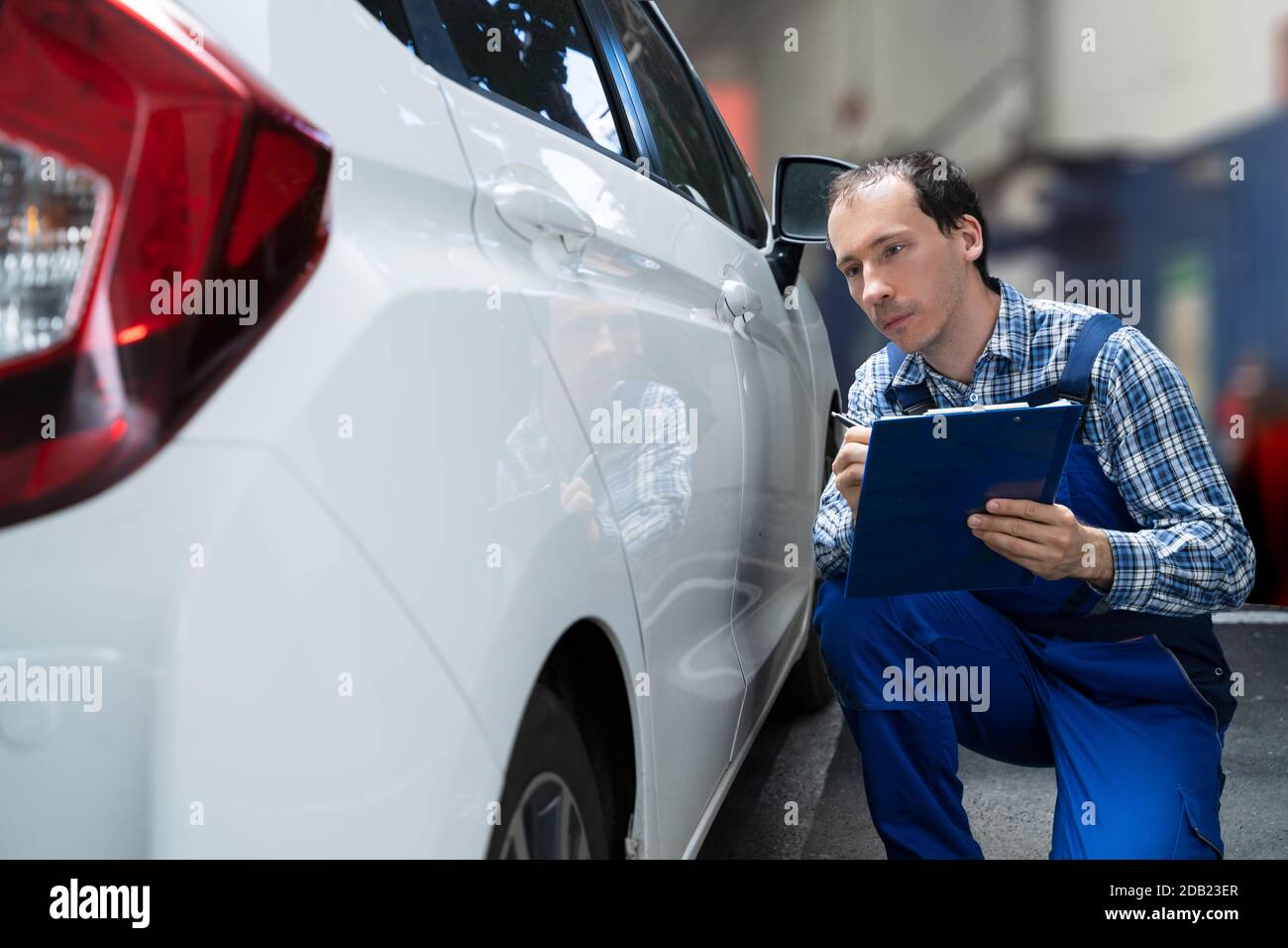 Insurance Agent Inspection White Car Paint For Scratches Stock Photo