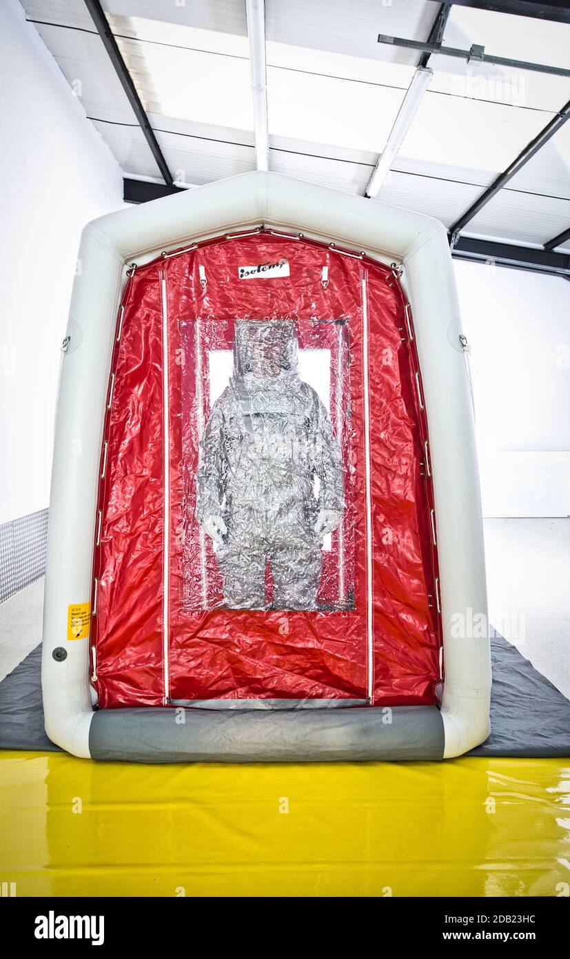 Man wearing a decontamination suit standing in decontamination tent. Stock Photo