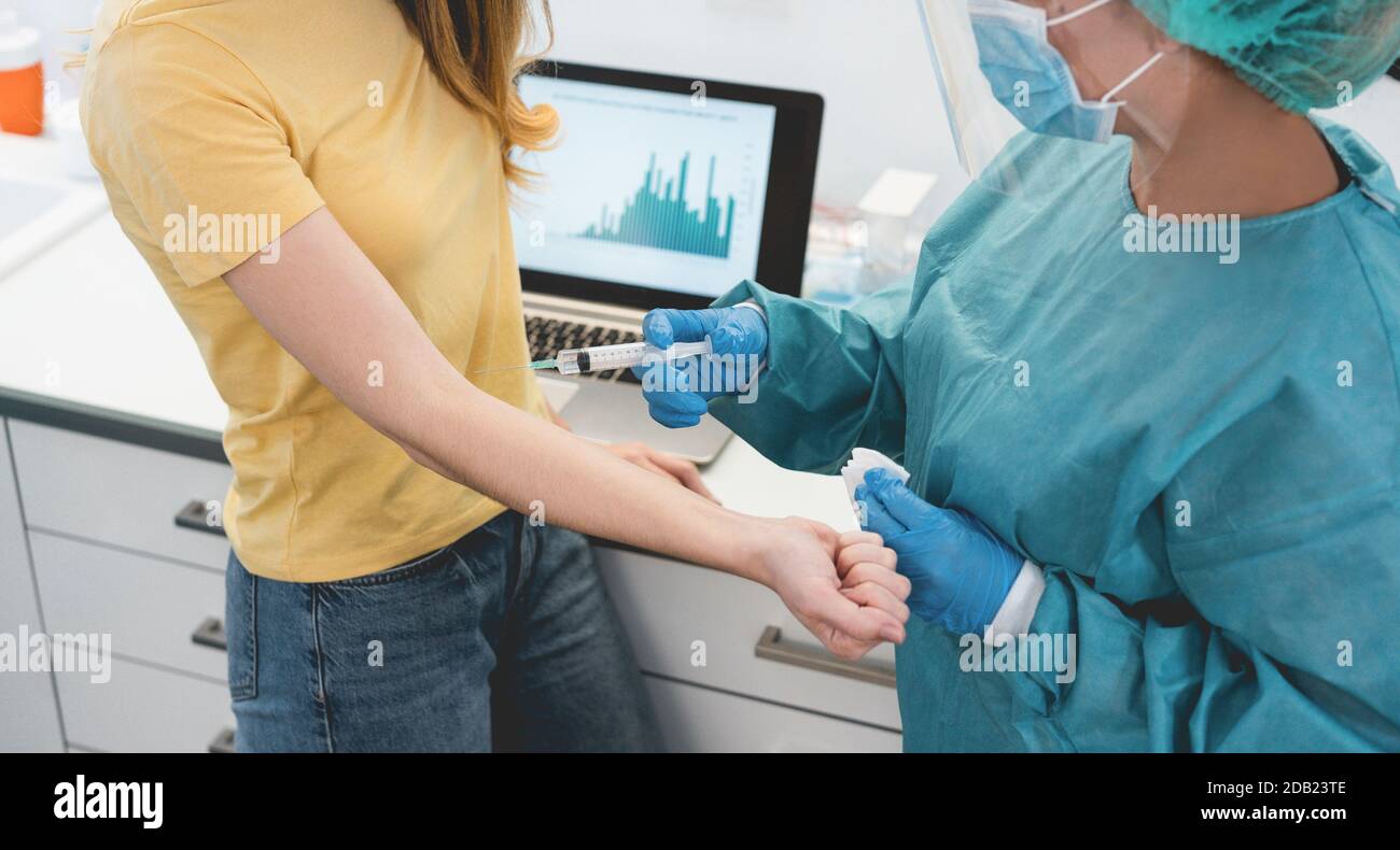 Doctor giving patient a vaccine for coronavirus disease - Medical and healthcare concept - Focus on syringe Stock Photo