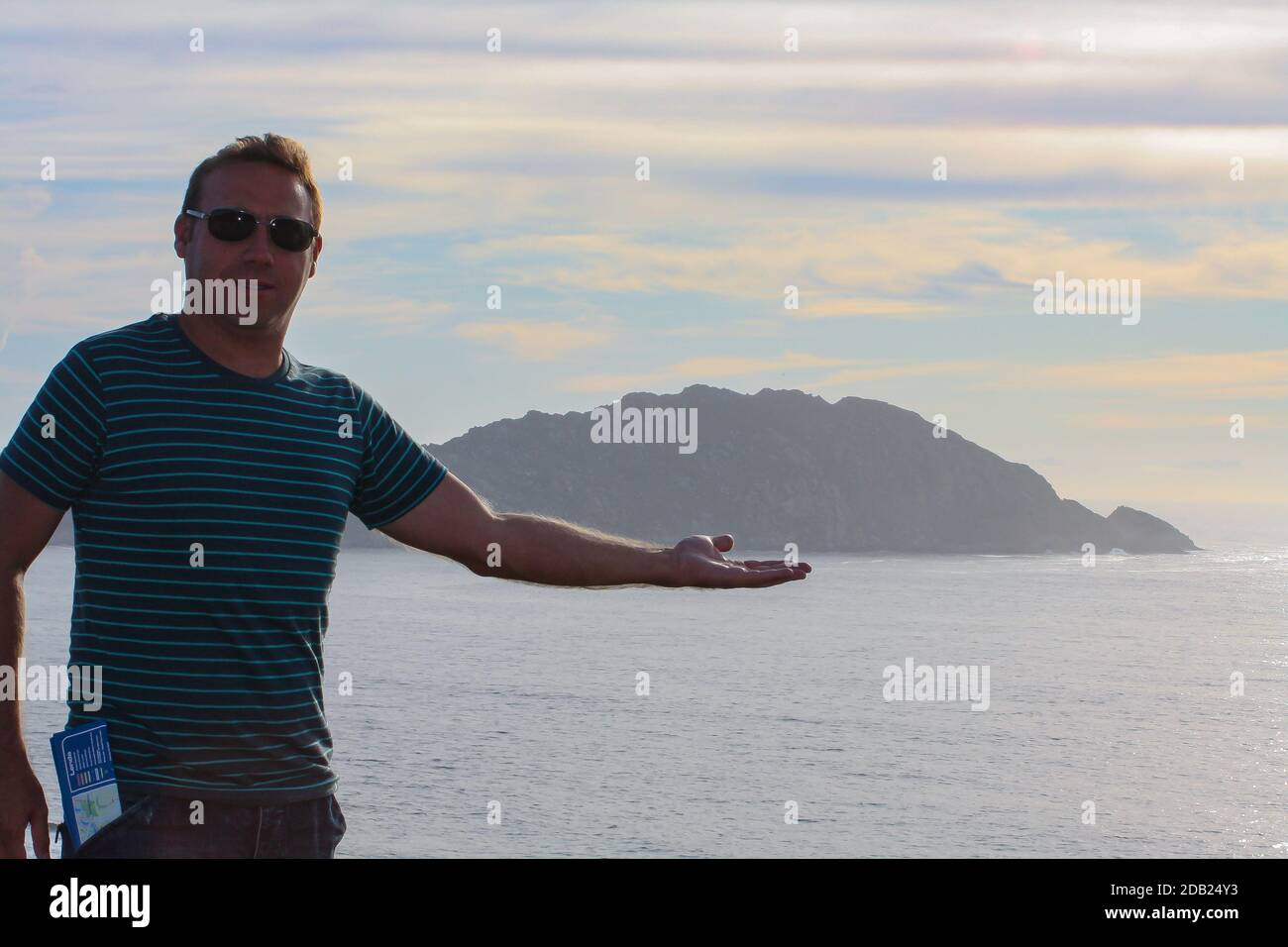 A Hispanic man posing for the camera on the field and mountain background in Donon, Galician, Spain Stock Photo