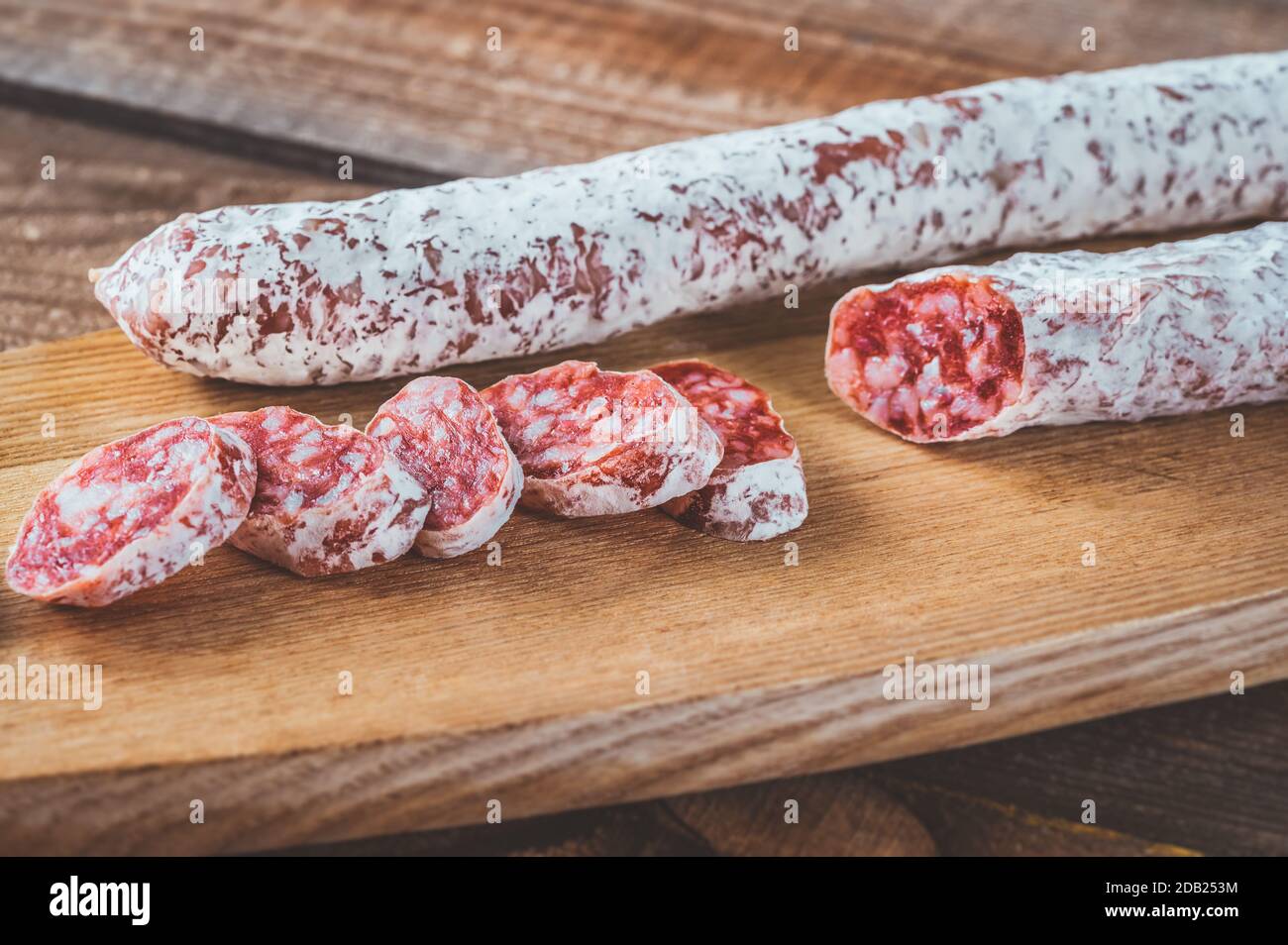 Fuet -  Catalan dry cured sausage on the wooden board Stock Photo