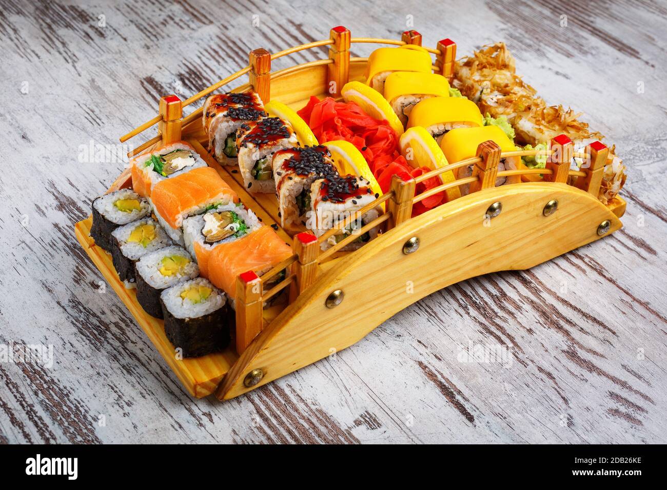 Great sushi set with a variety of roles on the original wooden tray, on a gray background. Restaurant serving Japanese dishes. Stock Photo
