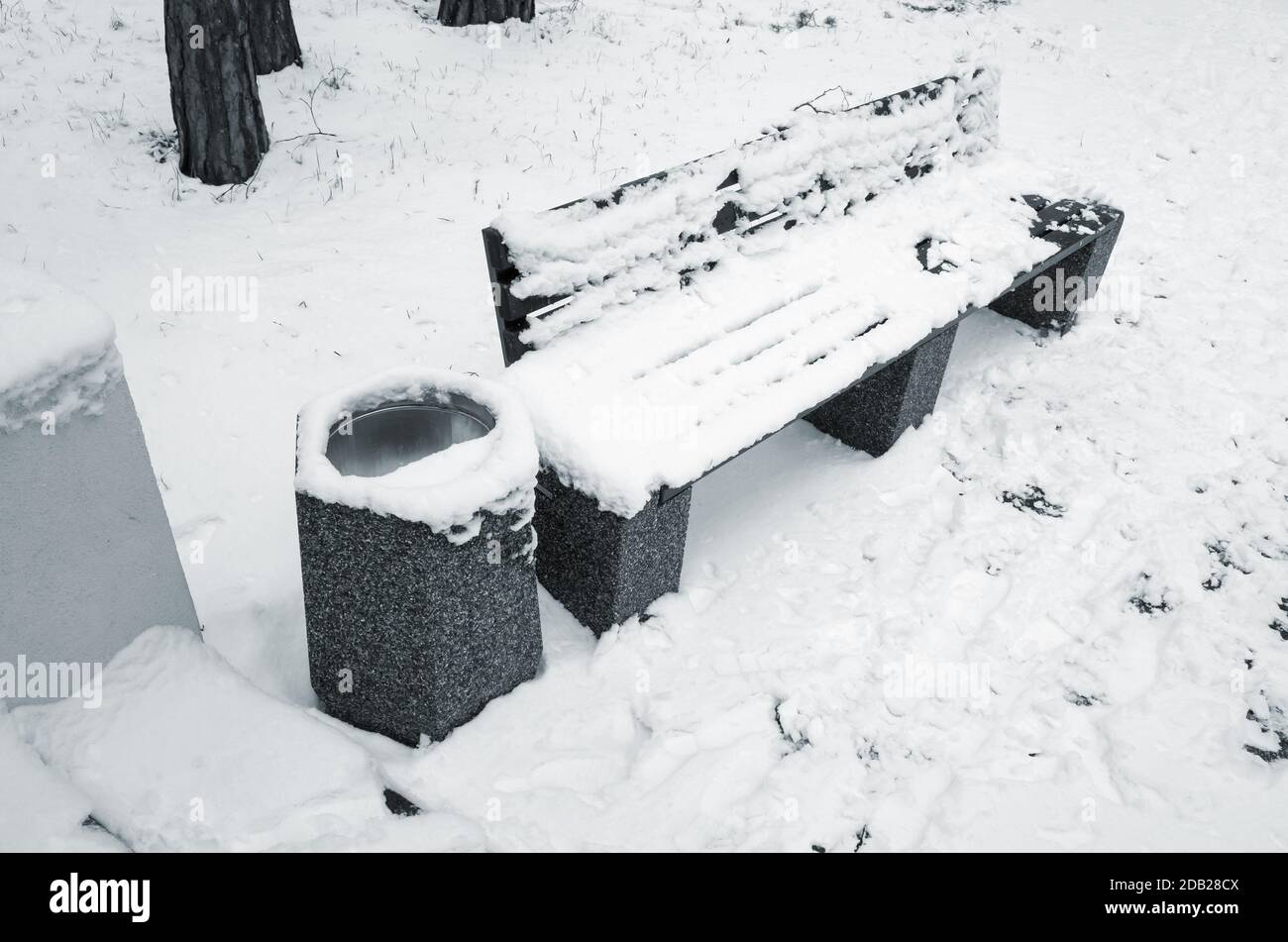 Outdoor bench and trash can covered with snow are in winter park Stock Photo