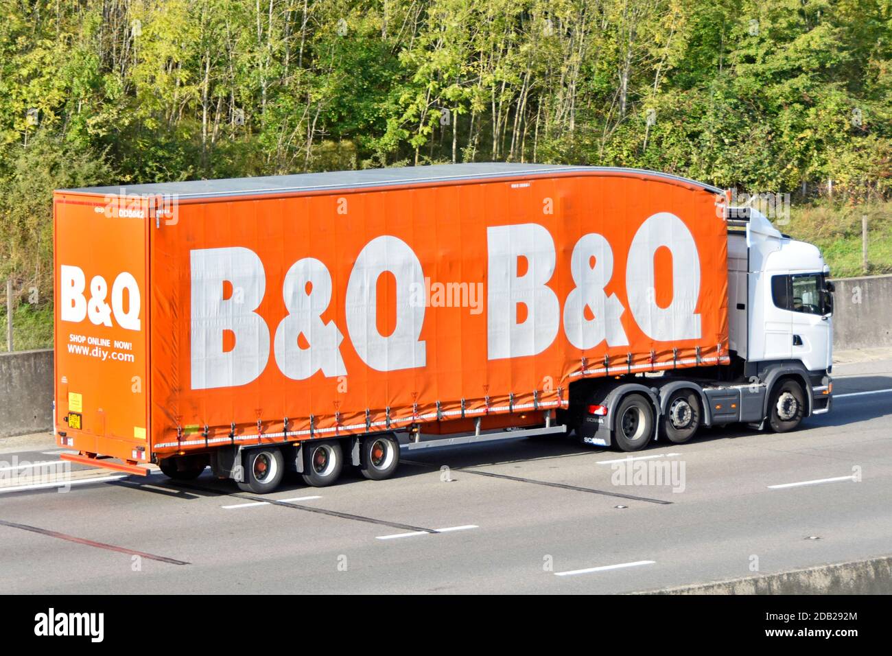 B&Q DIY retail & trade builders merchant business supply chain store delivery hgv lorry truck & side curtain trailer brand logo driving on UK motorway Stock Photo