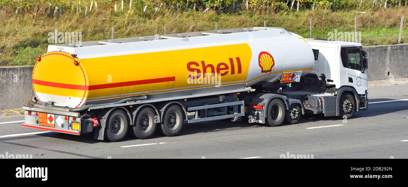 Side & back view Shell brand petrol fuel tanker trailer & Hoyer logistics supply chain business lorry truck with Hazchem warning sign on UK motorway Stock Photo